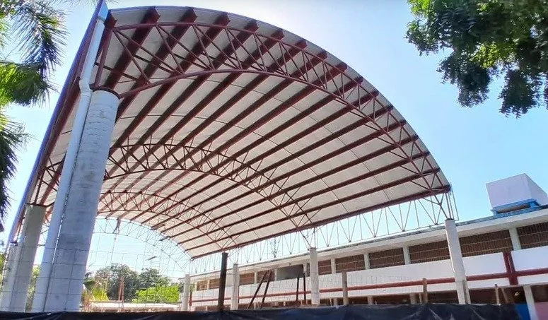 Domo de estructura metálica en arco con armaduras de acero sobre patio escolar en Cancún, Seaak BS.