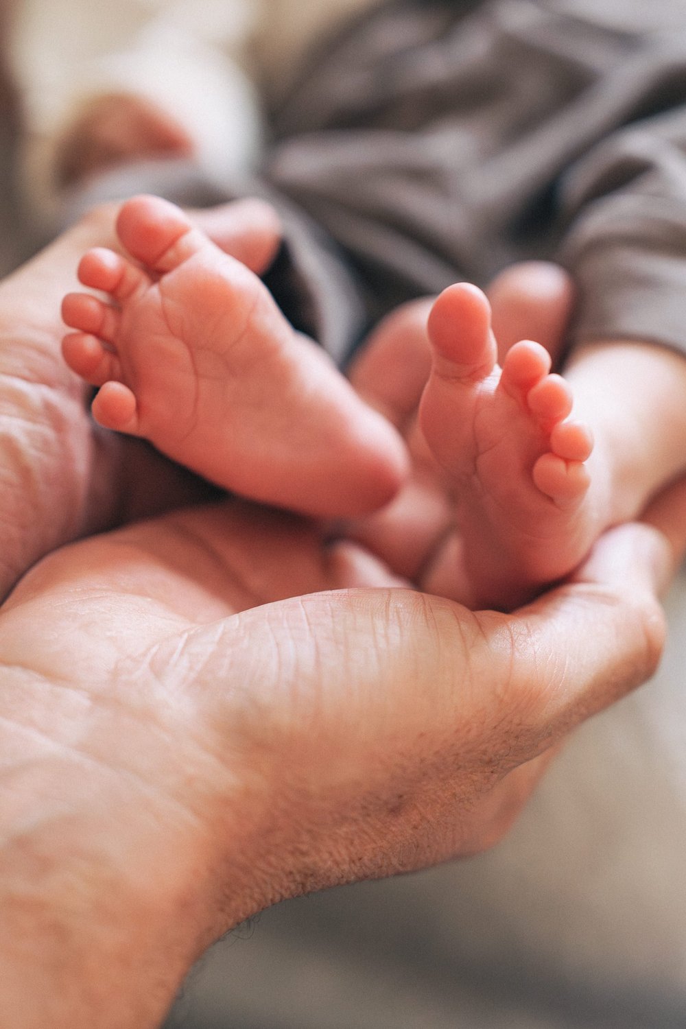 Tiny newborn feet held in dad&rsquo;s hands, Hunter family in-home session Rancho Mission Viejo