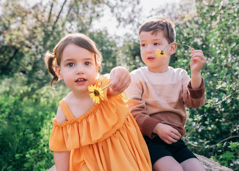 Brother and sister offering wildflowers
