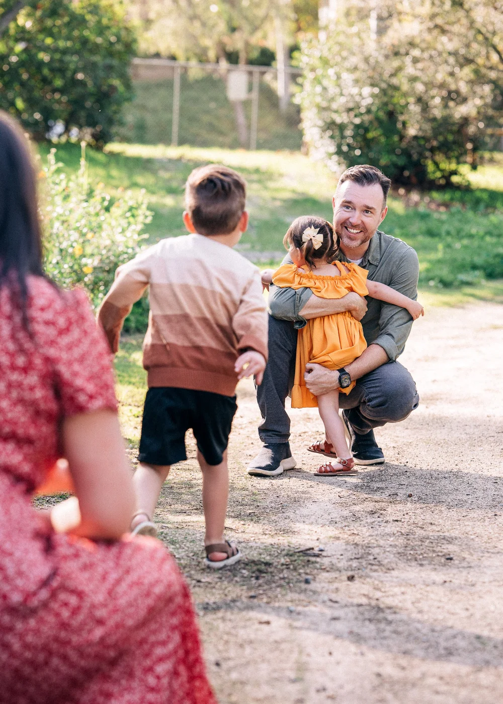Dad with daughter as son runs to greet them