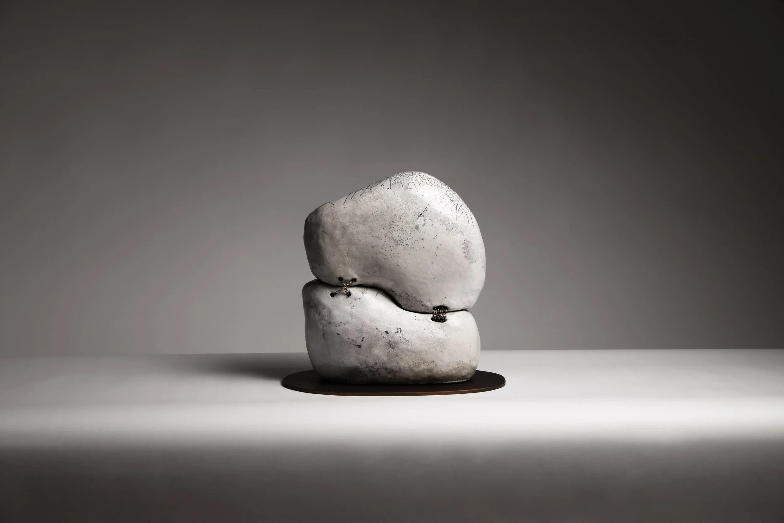 Contemporary Raku ceramic sculpture by Neil Baldacci, Tsunagi series NEI.TSG.01, featuring handcrafted fragments joined by brass stitches.