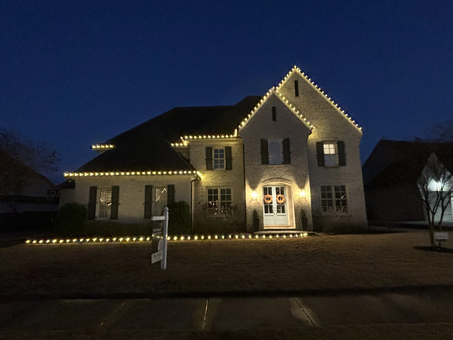 Home outlined in warm white lights at dusk