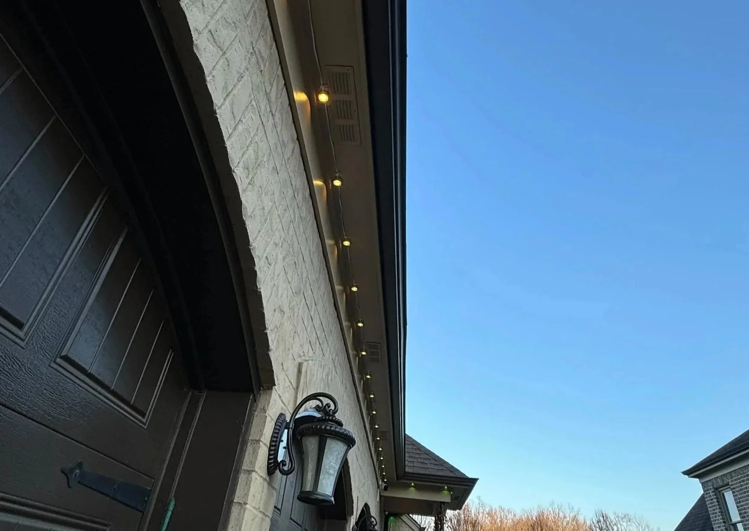 Permanent LED lights tucked into trim near a front entry during the day