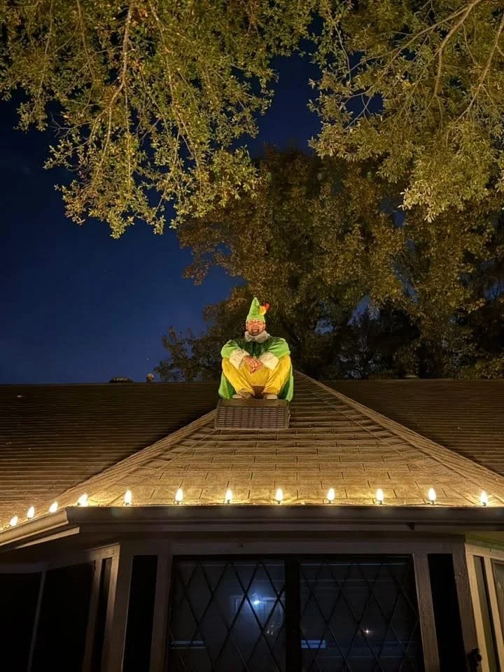 Elf crew member working on a rooftop at dusk