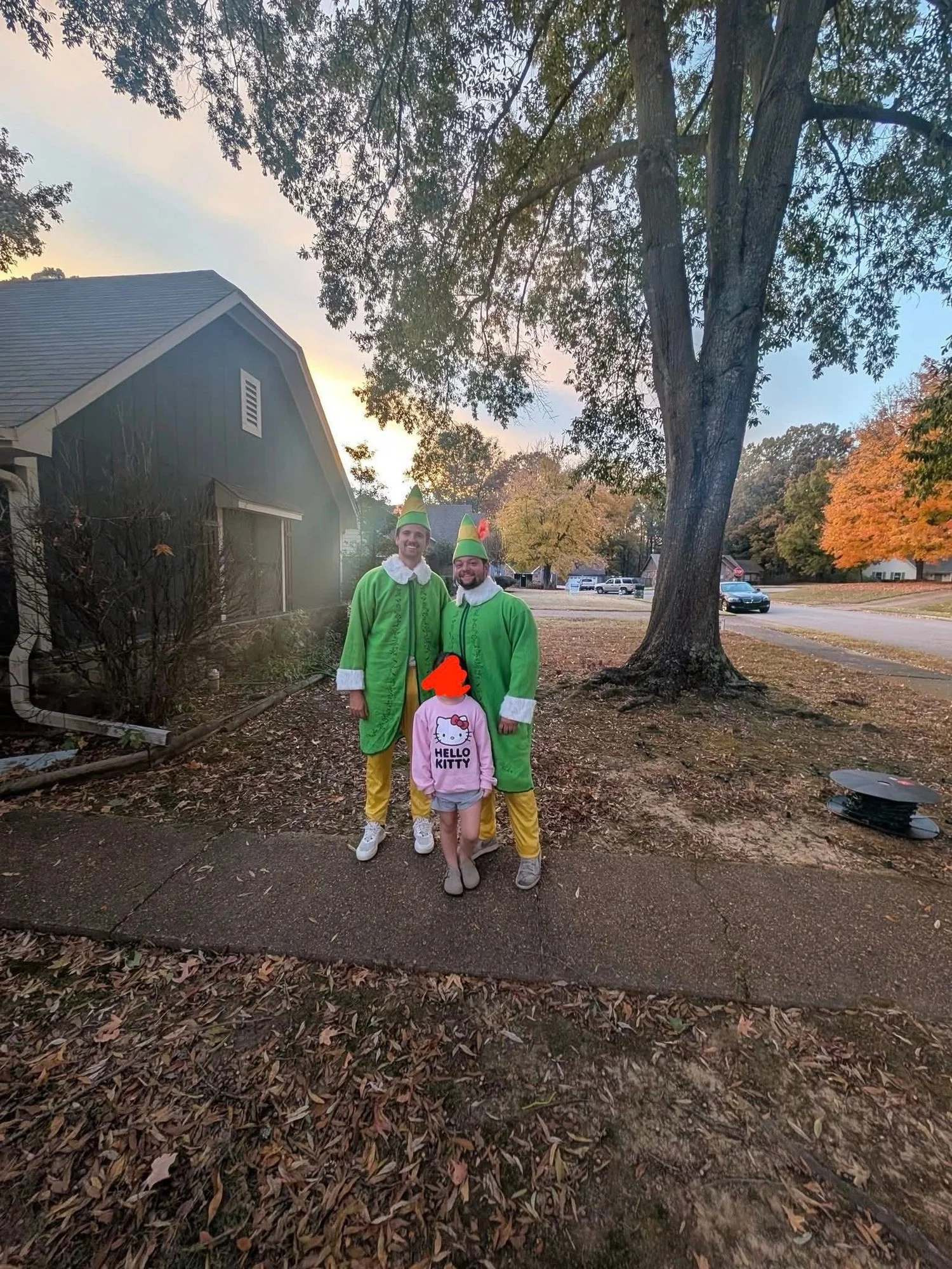 Elf crew with a child on a driveway after an install