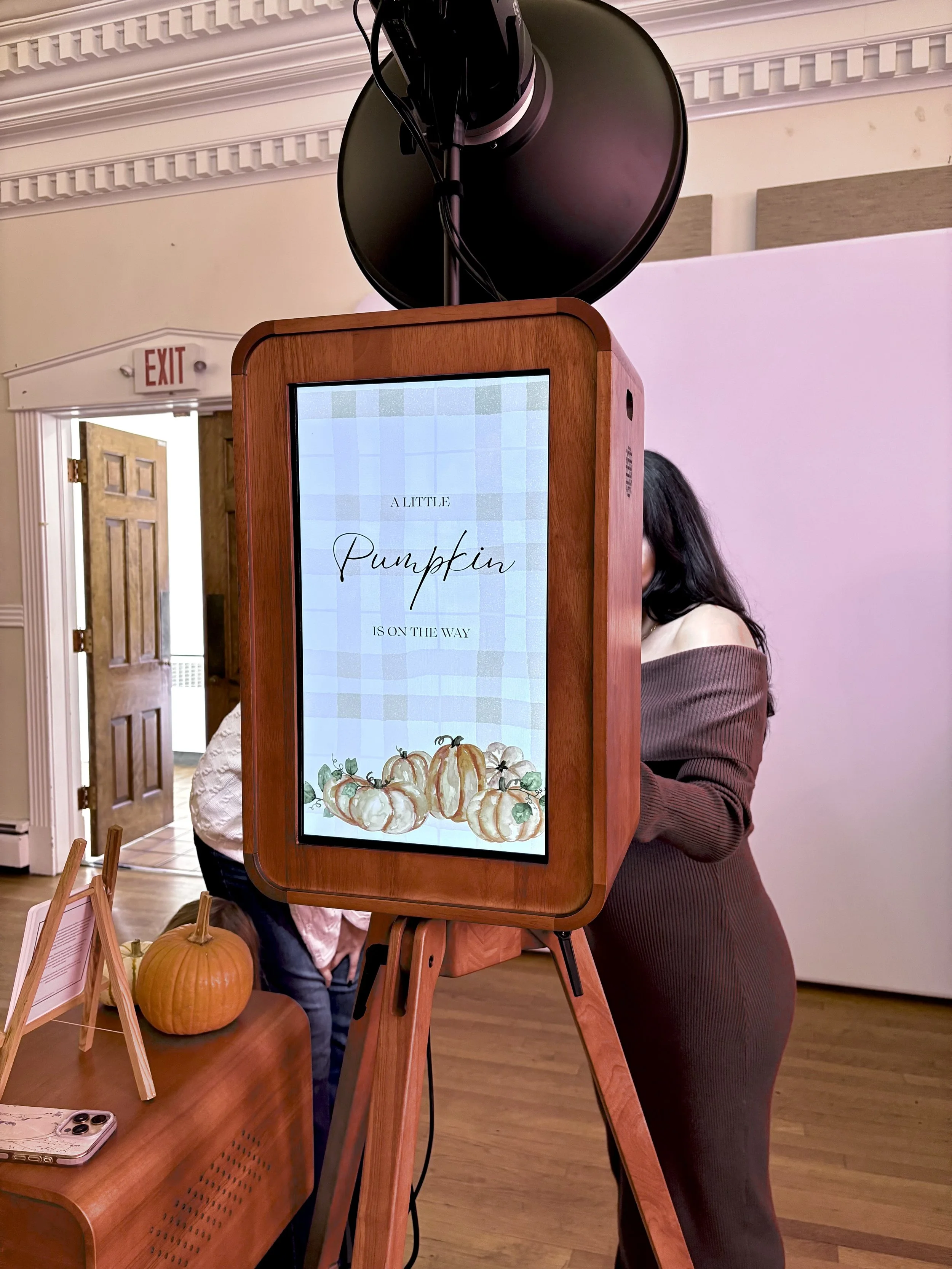 A wooden photobooth with a screen that displays custom designs tailored to your event