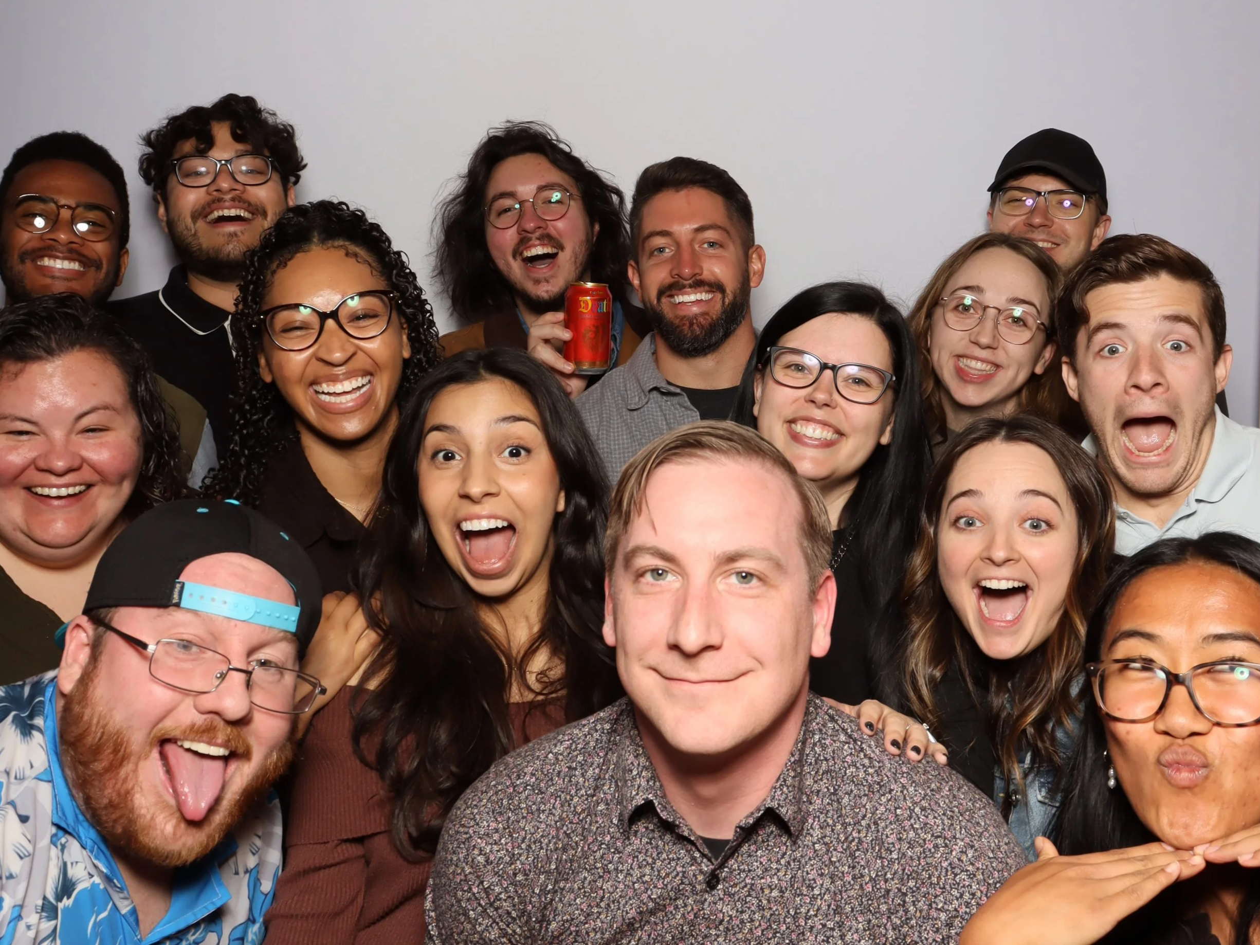 Group of diverse smiling people taking a selfie together using a premium photobooth rental