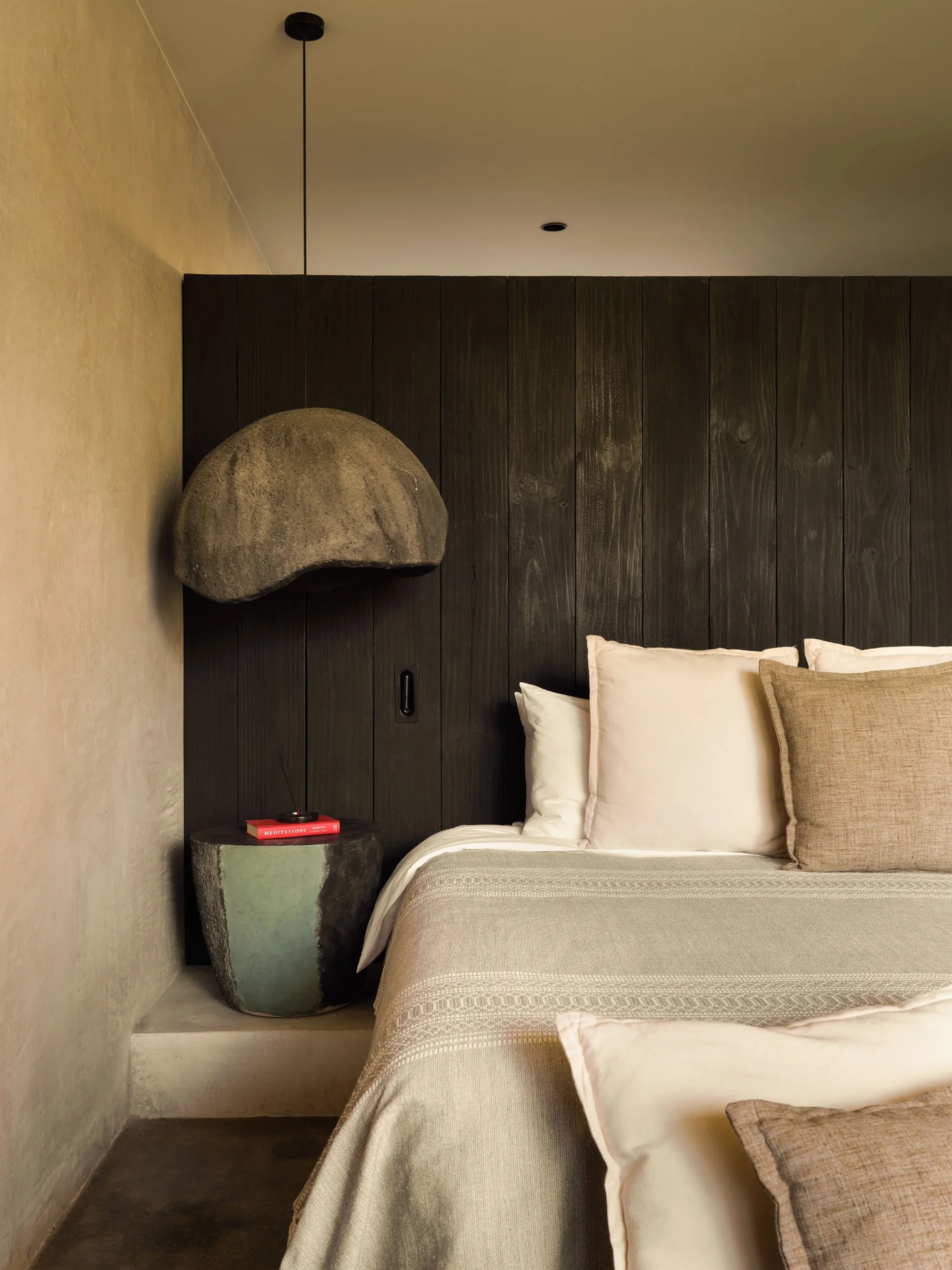 Hotel ESH guest bedroom in Huacas, Nosara, Costa Rica, with dark timber wall, linen bedding and stone pendant, by FAMM Arquitectura