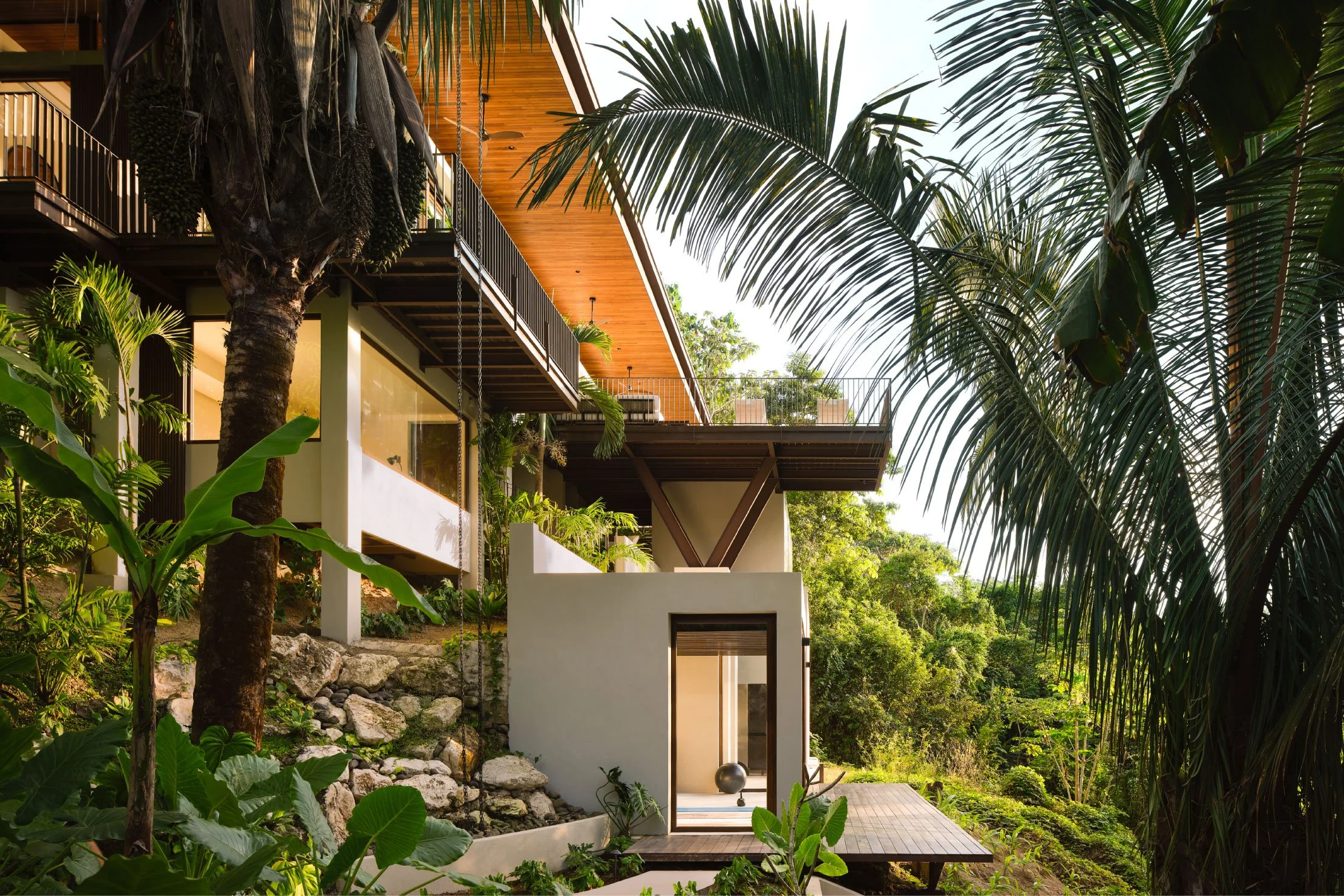 Minibauta House on its sloping site in Santa Teresa, Costa Rica, with timber roof and tropical canopy, by FAMM Arquitectura