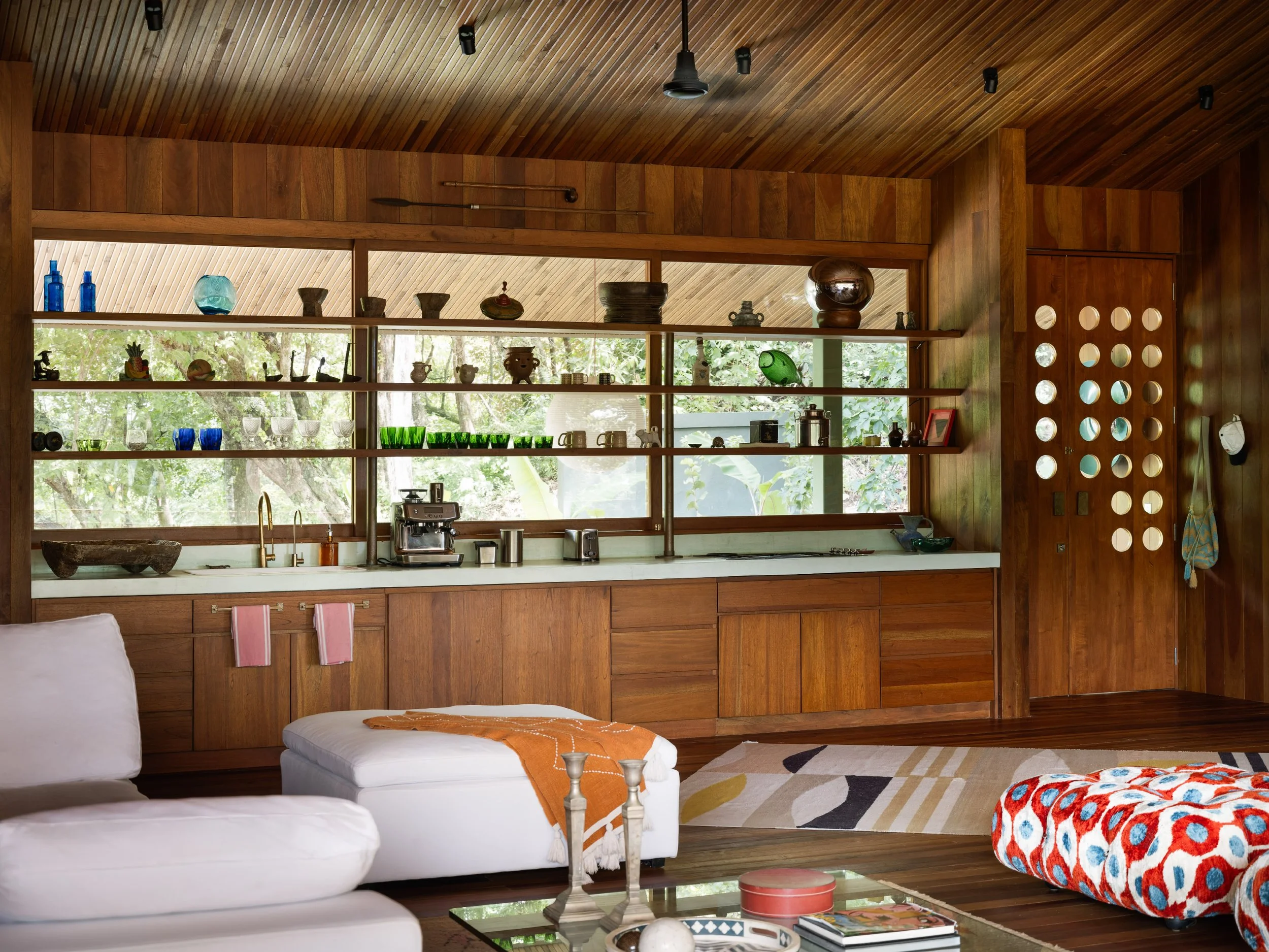 Al Suave House kitchen in Santa Teresa, Costa Rica, with glazed shelving and white sofa, FAMM Arquitectura