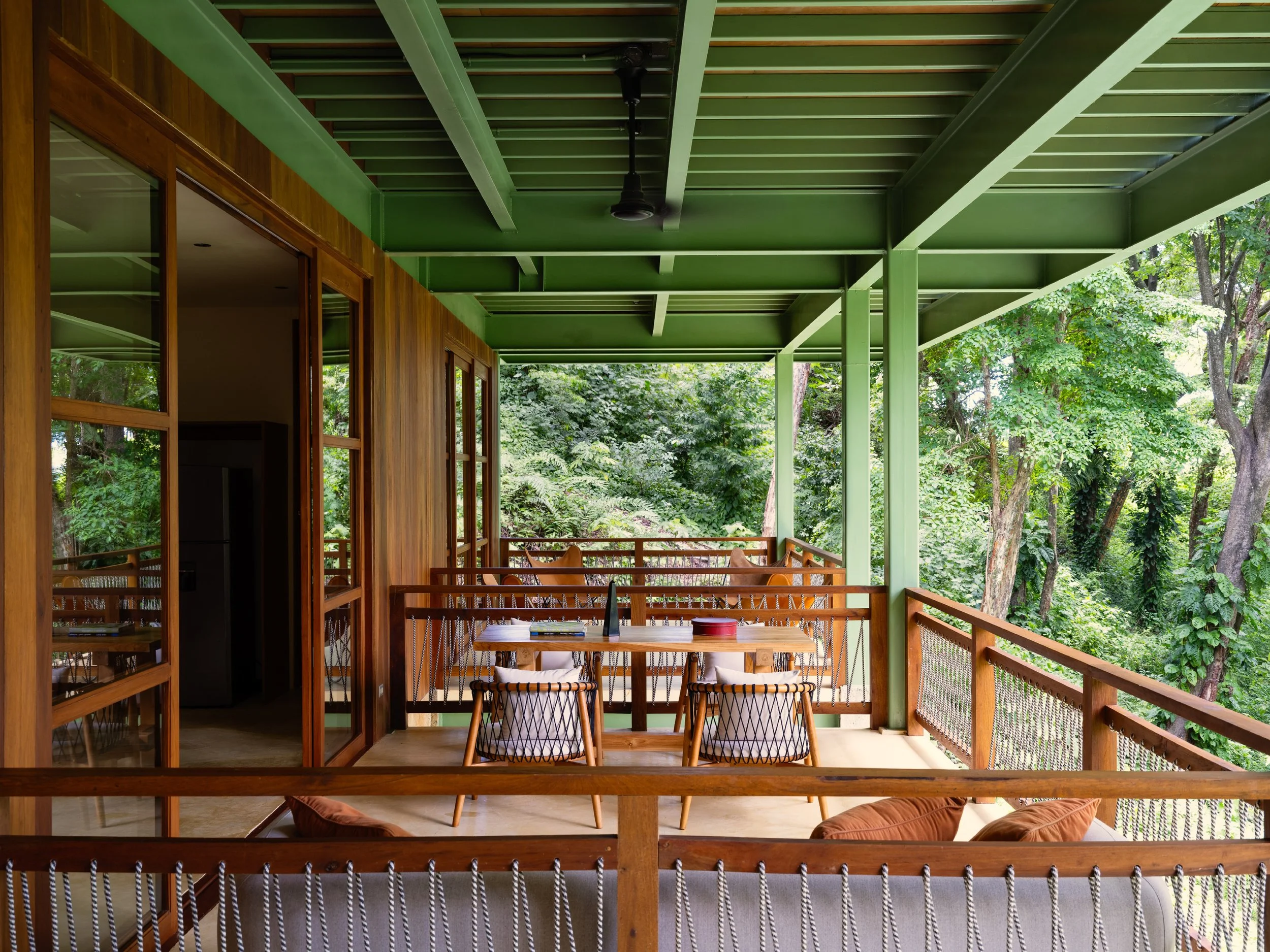 Al Suave House covered terrace in Santa Teresa, Costa Rica, with green ceiling and timber railing, FAMM Arquitectura