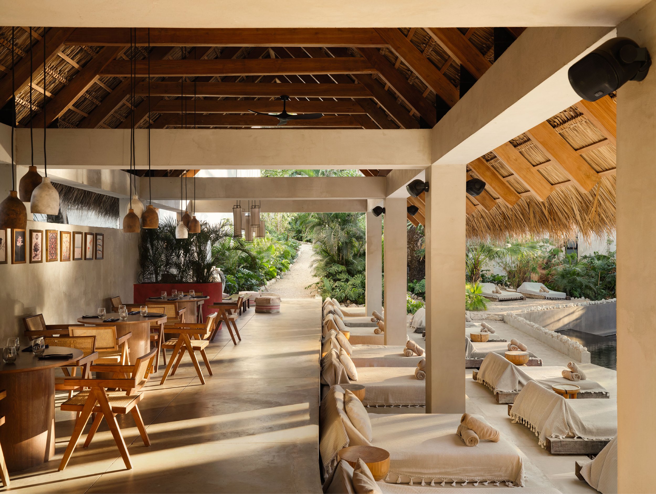 Hotel ESH restaurant in Huacas, Nosara, Costa Rica, with cane chairs, pendant lamps and pool daybeds, by FAMM Arquitectura