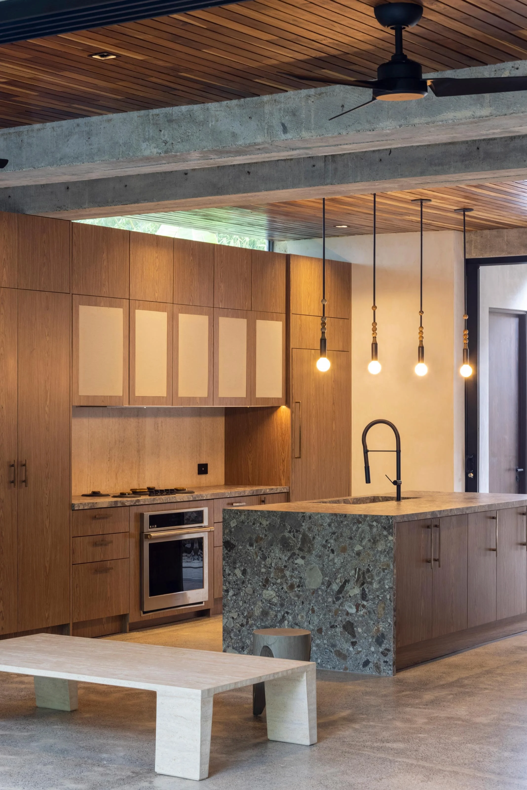 Casa Jungla kitchen in Santa Teresa, Costa Rica, with timber cabinetry, stone island and pendant lights, by FAMM Arquitectura