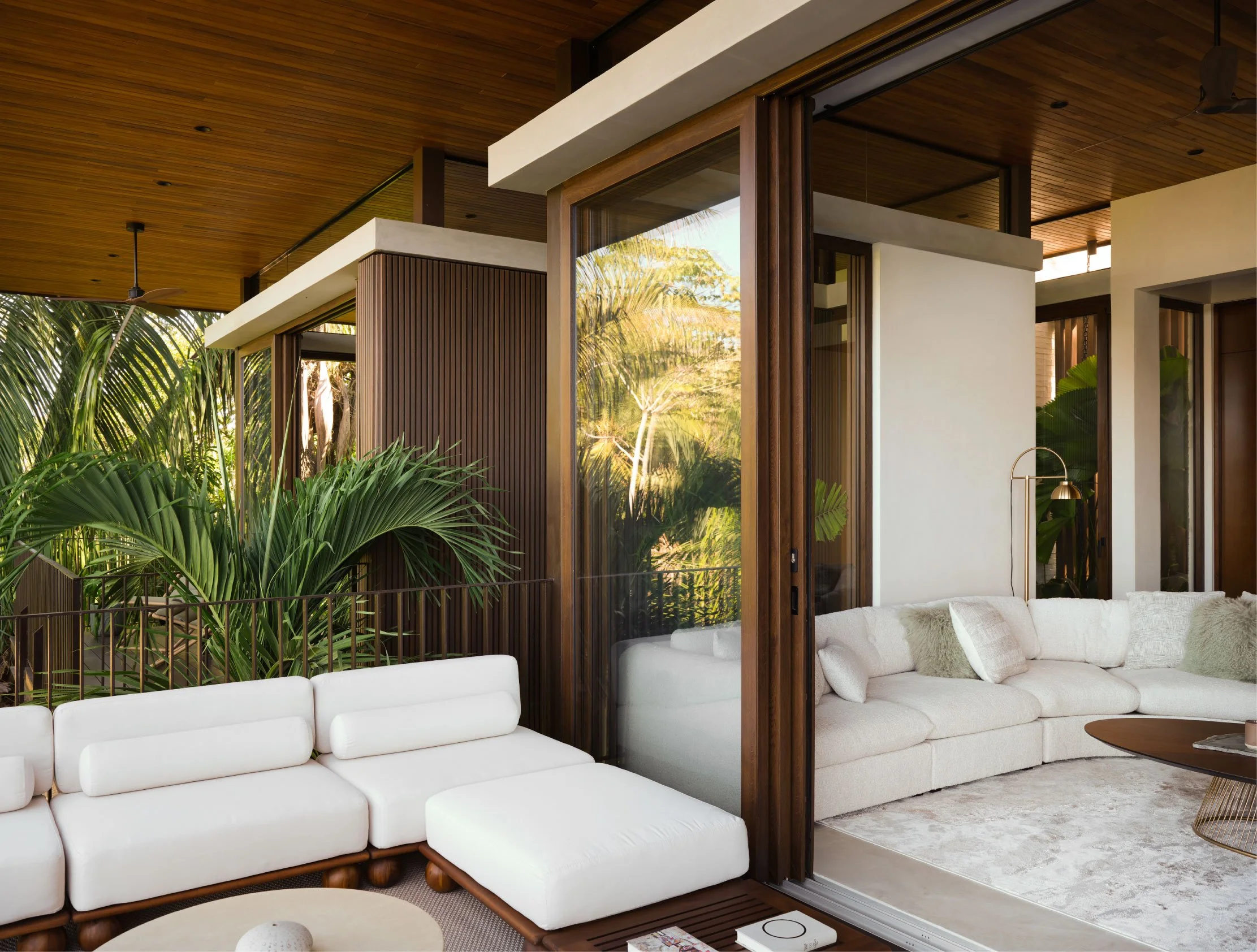 Minibauta House living room in Santa Teresa, Costa Rica, with white sofas, timber ceiling and sliding glass doors, by FAMM Arquitectura