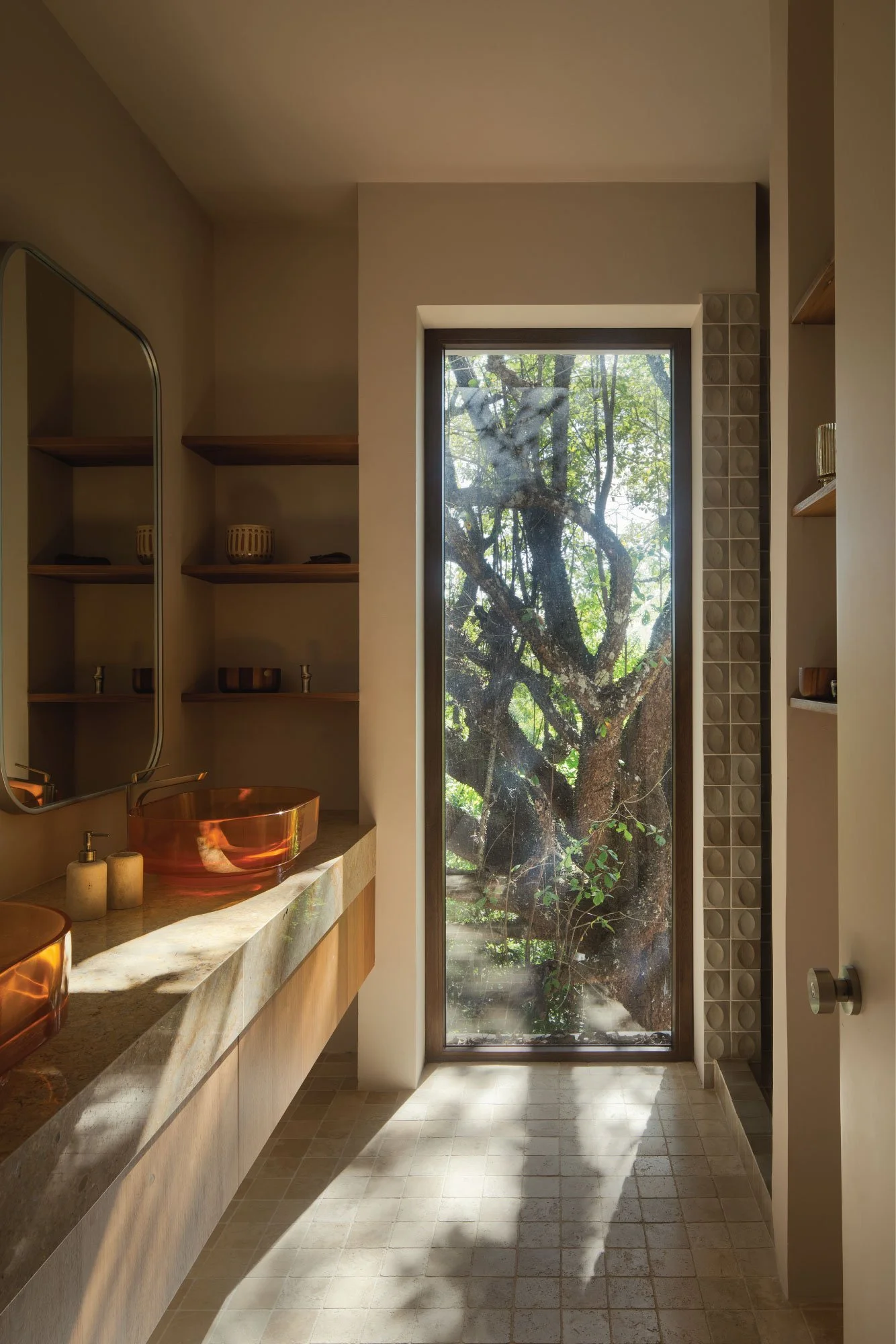 Tres Pochotes House bathroom by FAMM Arquitectura — stone vanity and full-height window framing a tree, Playa Hermosa, Costa Rica