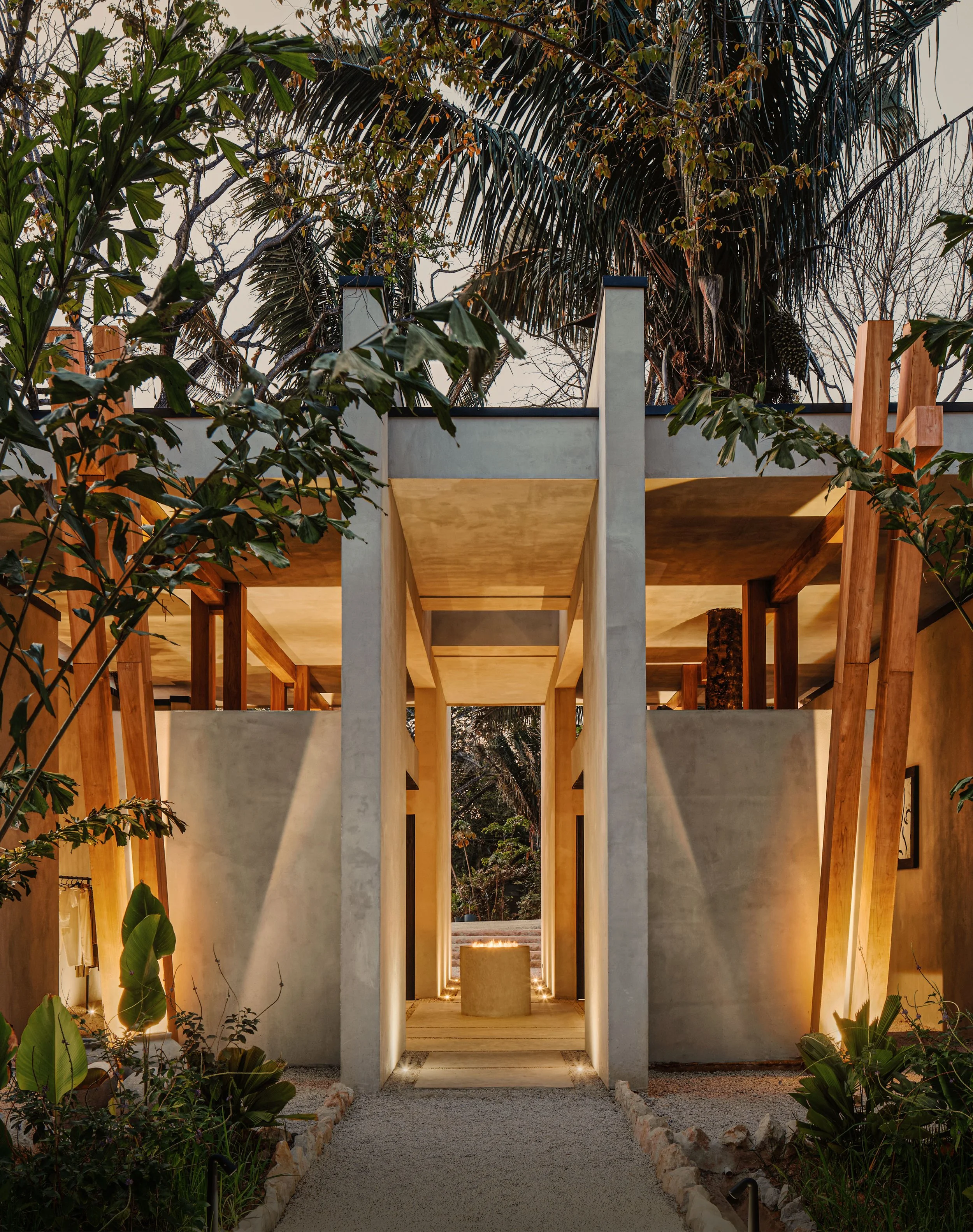 Hotel ESH entrance walkway in Huacas, Nosara, Costa Rica, between concrete walls and timber posts, by FAMM Arquitectura