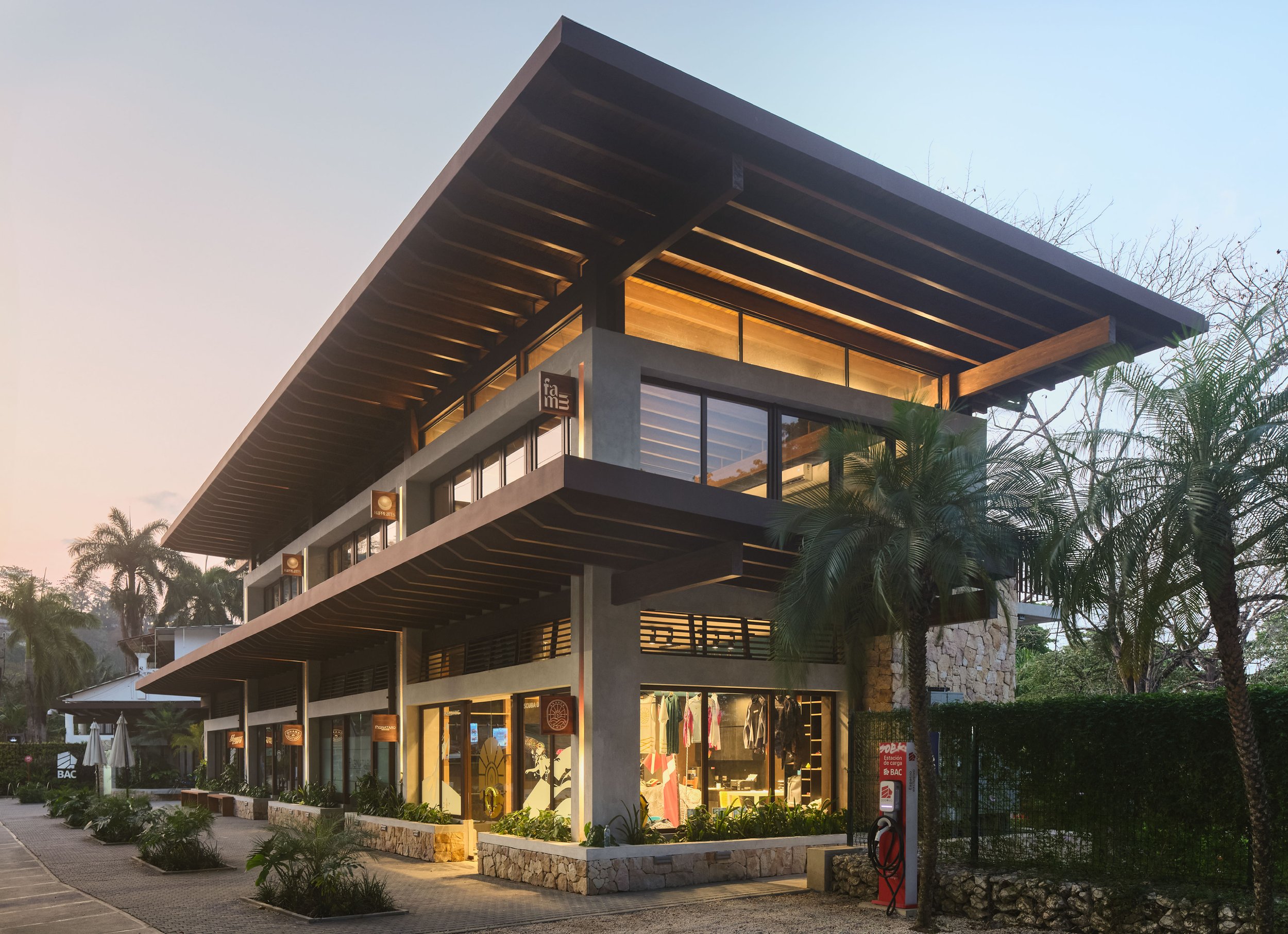 Plaza Pochote corner with cantilevered timber canopy and palm trees in Santa Teresa, Costa Rica, by FAMM Arquitectura