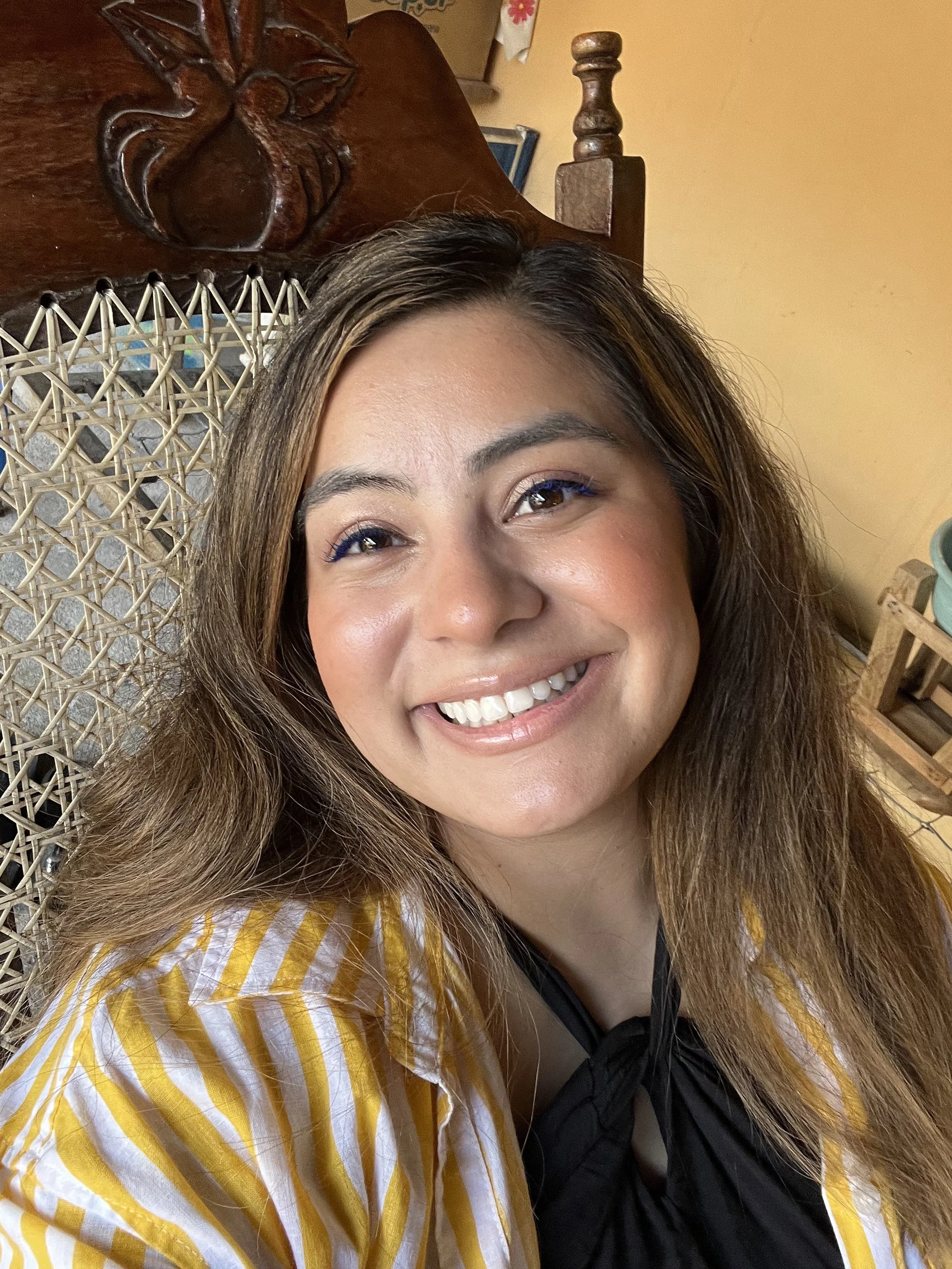 Photo of psychotherapist Ana V. Lozano, in a comfortable rocking chair smiling