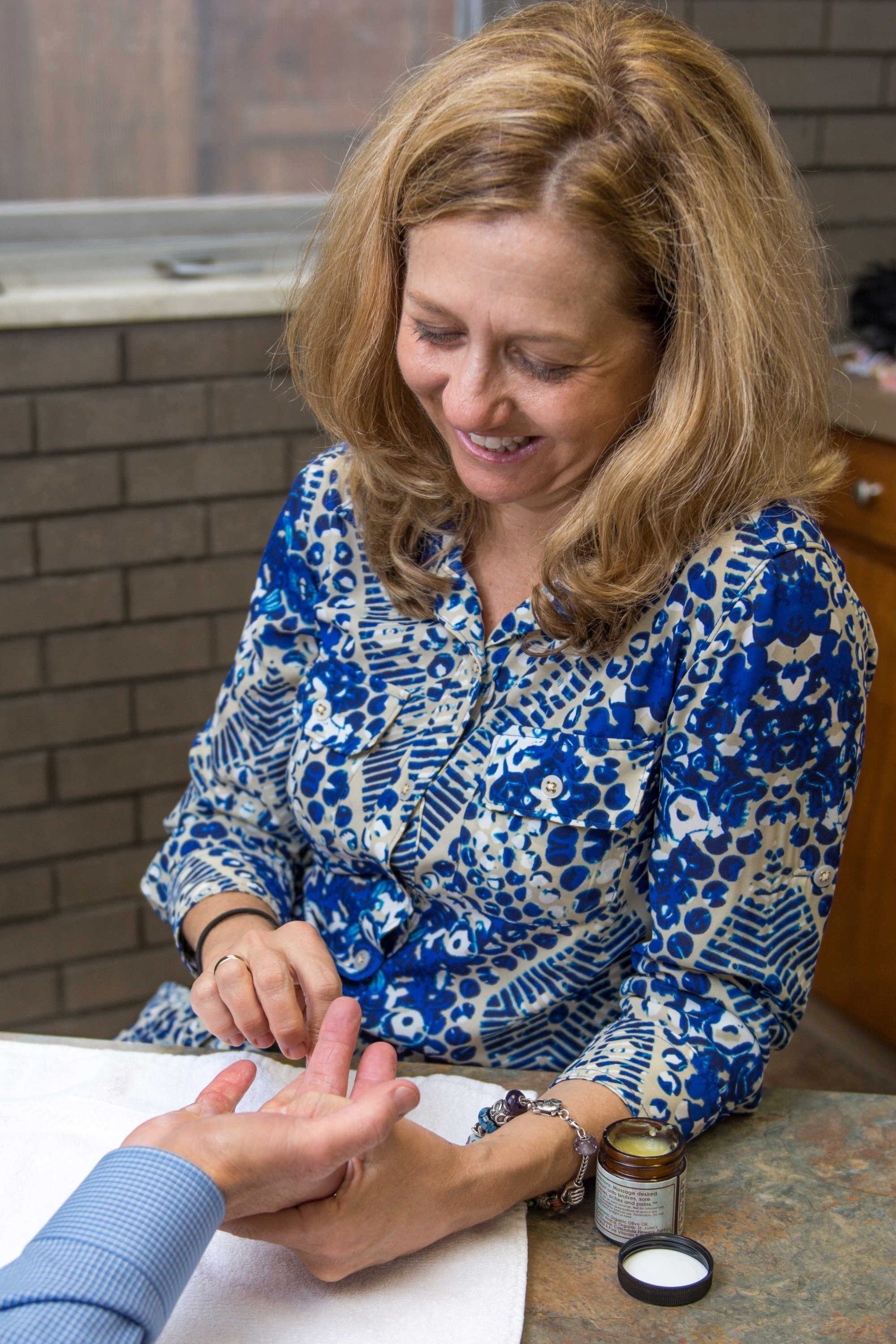 A woman receiving a manicure from a technician at a nail salon.