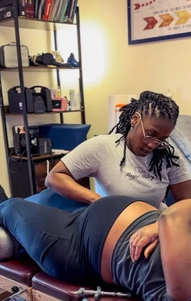A woman receiving a chiropractic adjustment from Dr. Magen in an office setting.
