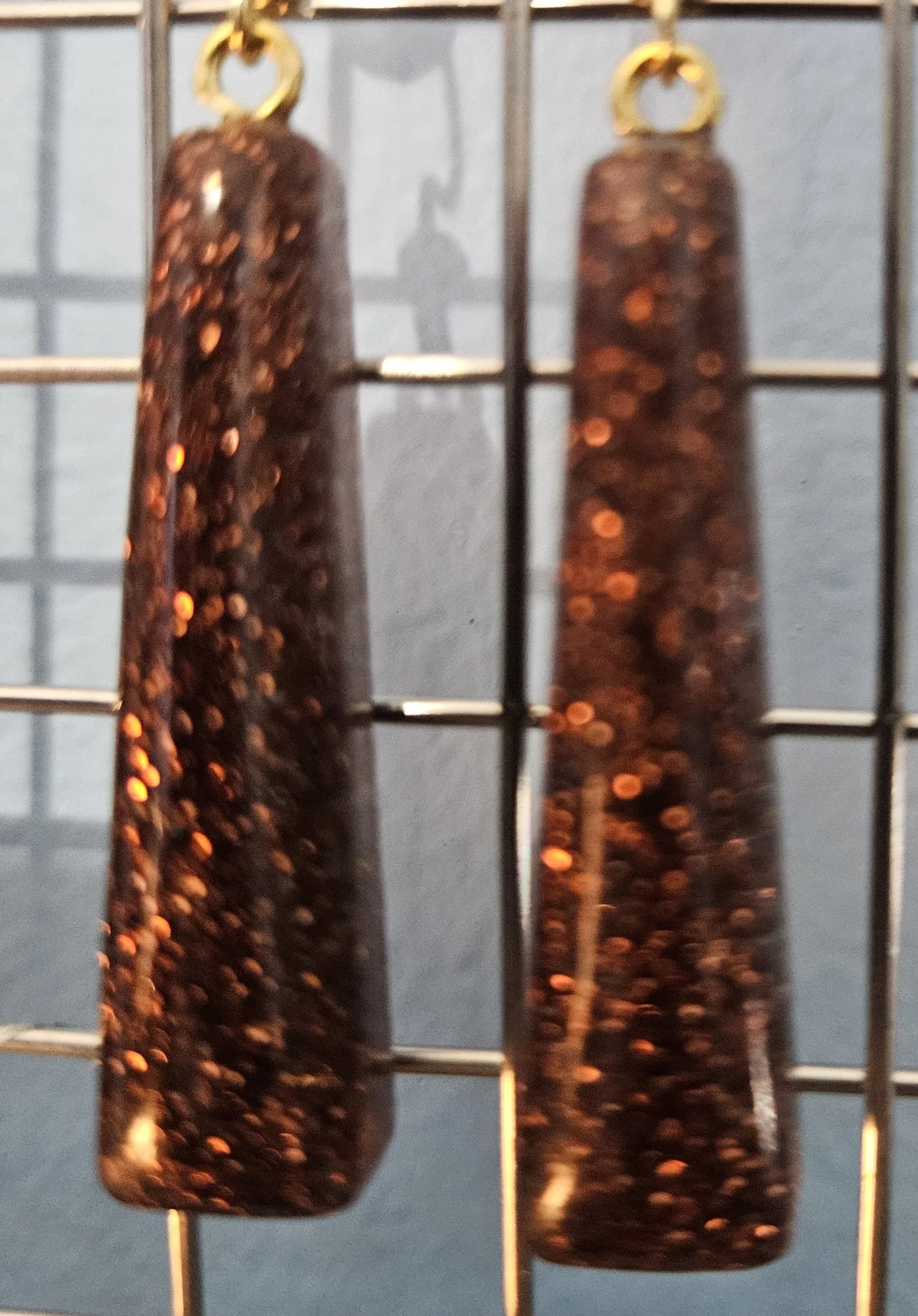 Fine brown glitter encased in clear hard resin.