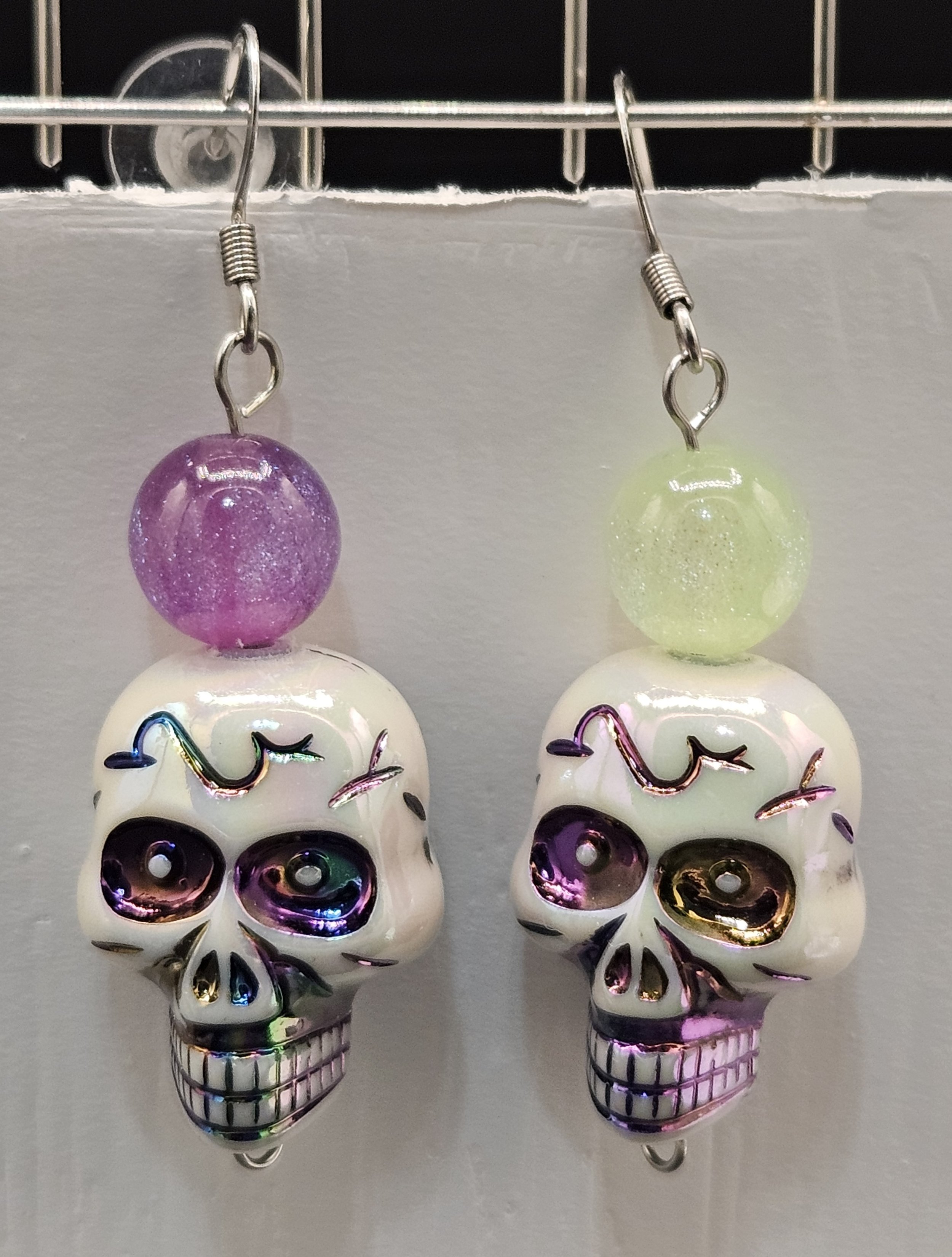 Day of the Dead skull earrings. Purple and green glass beads.
