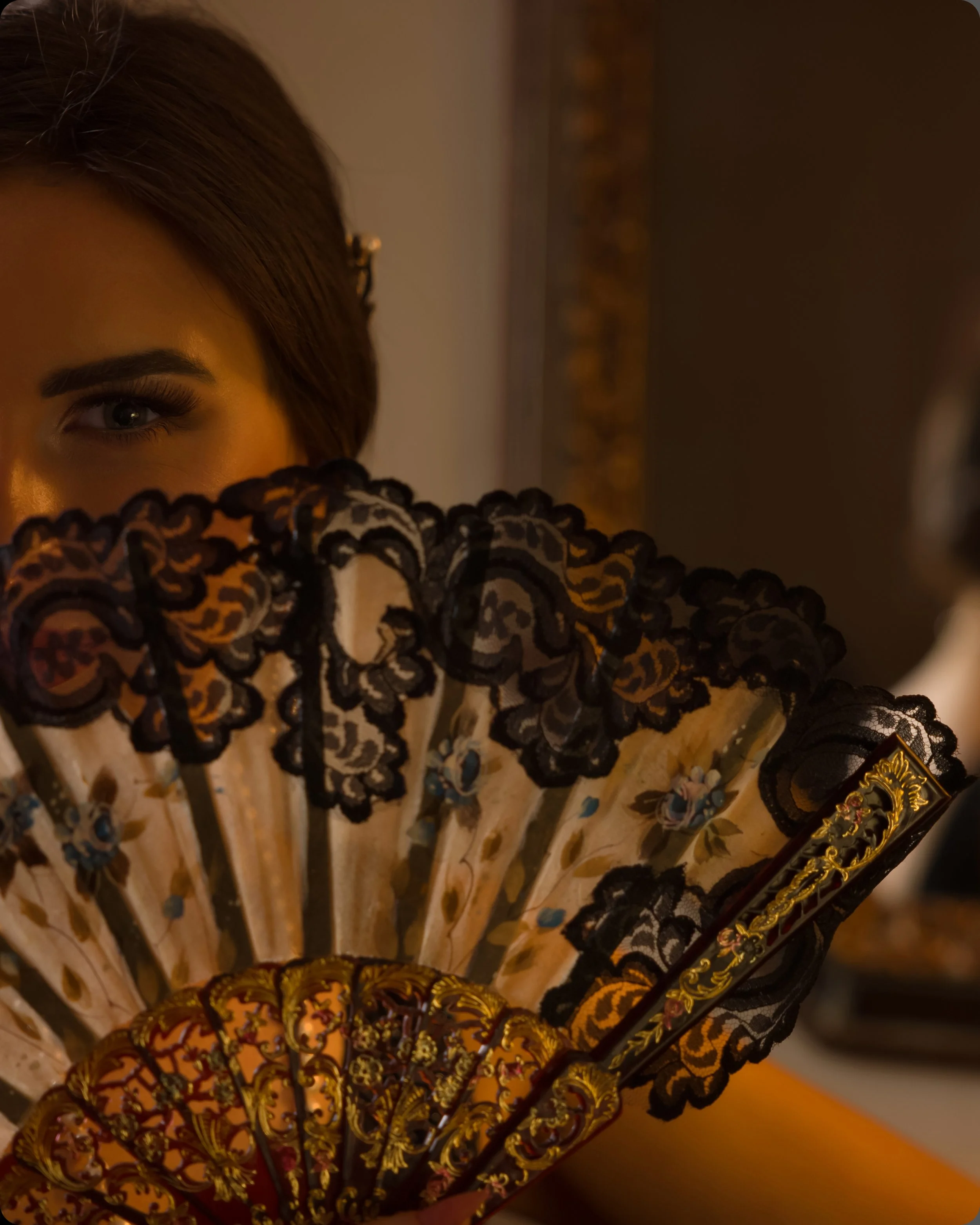 Woman smiling behind lacy fan