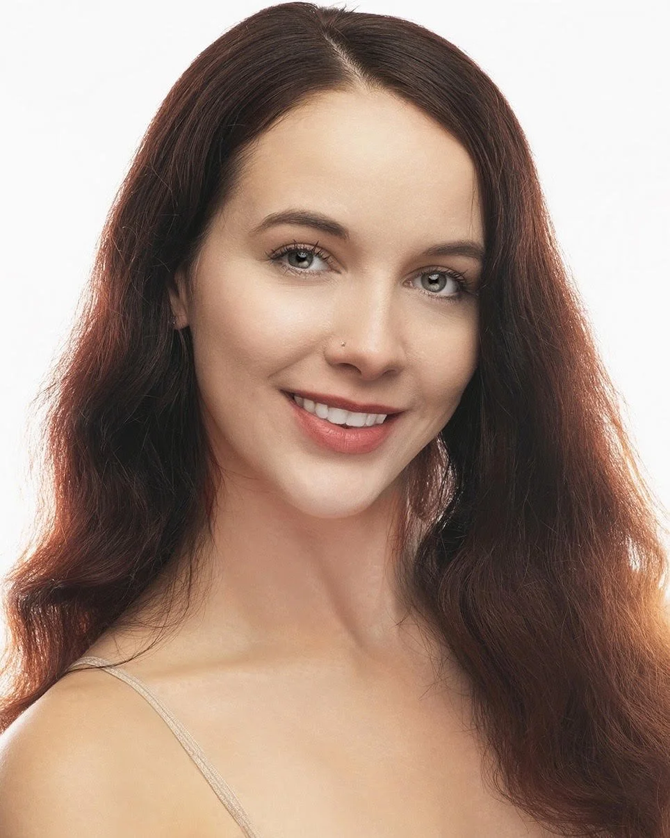 A woman with long brown hair and smiling