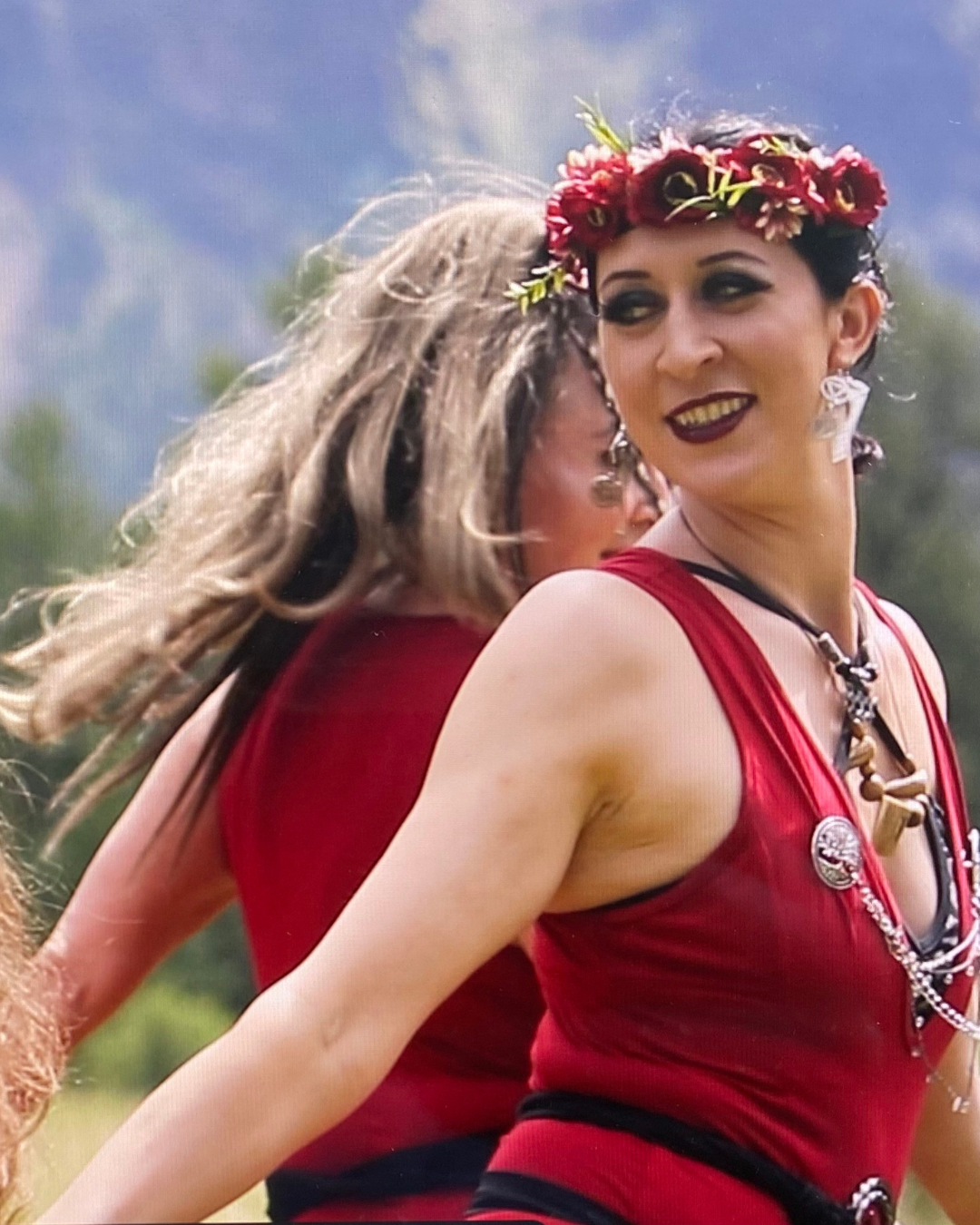 Two women wearing red bellydancing and smiling
