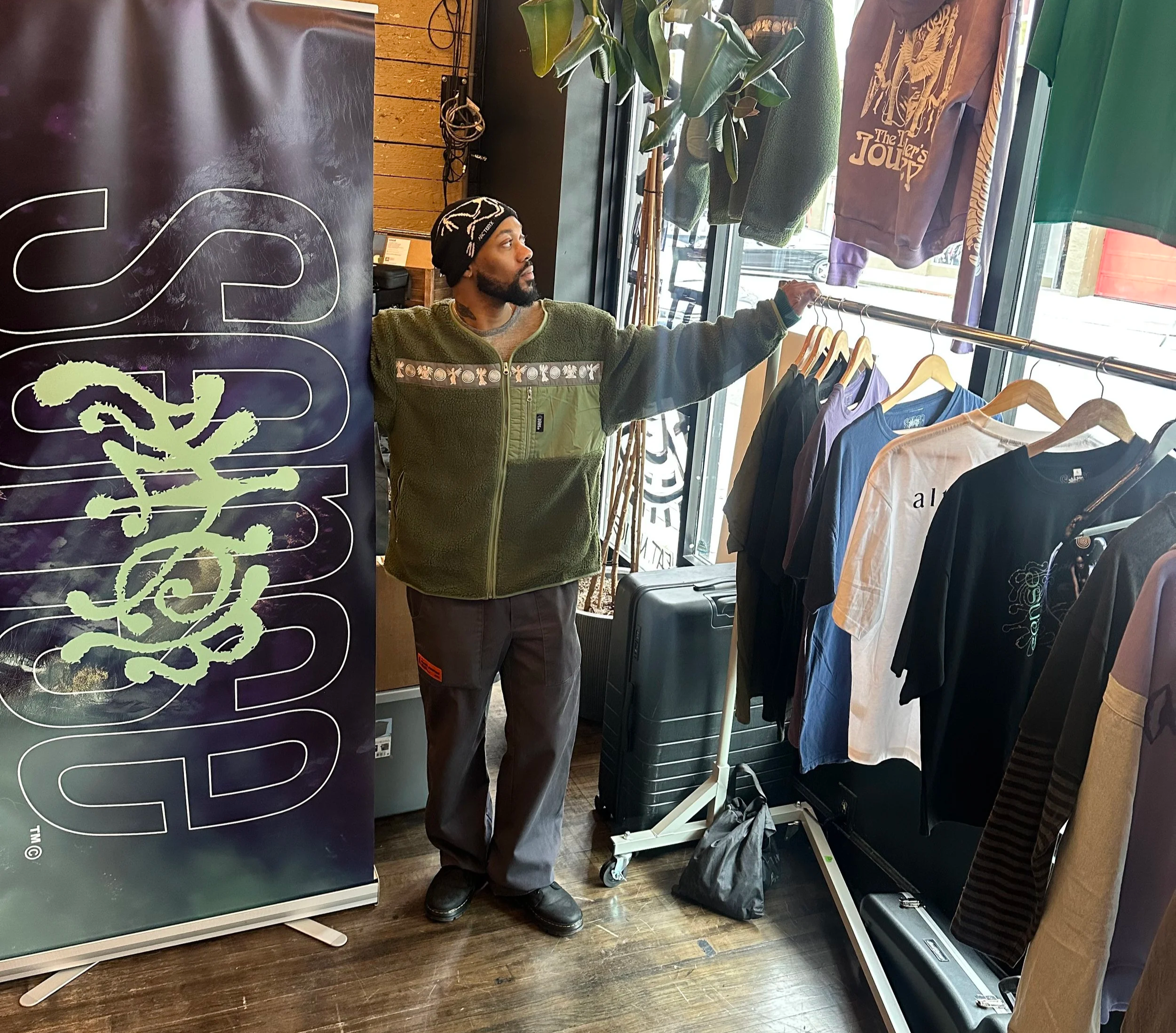 Ty from Alter Sense poses in front of his racks of streetwear at Eleven:Eleven, on Capitol Hill Seattle