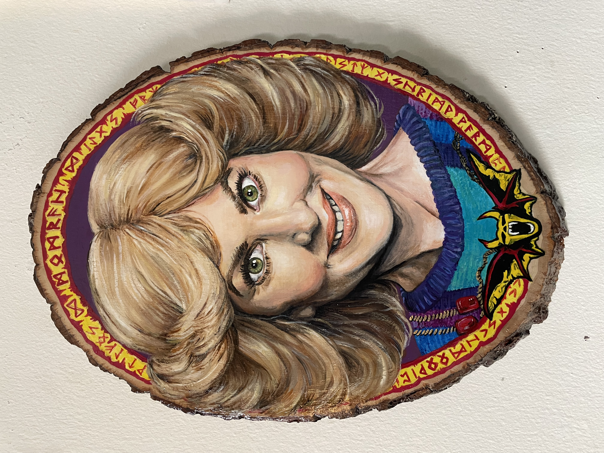 A large portrait of a television character with elaborate feathered hair and an intense expression painted in acrylic on a large oval slice of wood, commissioned to mimic the look of the Ozzy Ozbourne Speak of the Devil album cover.