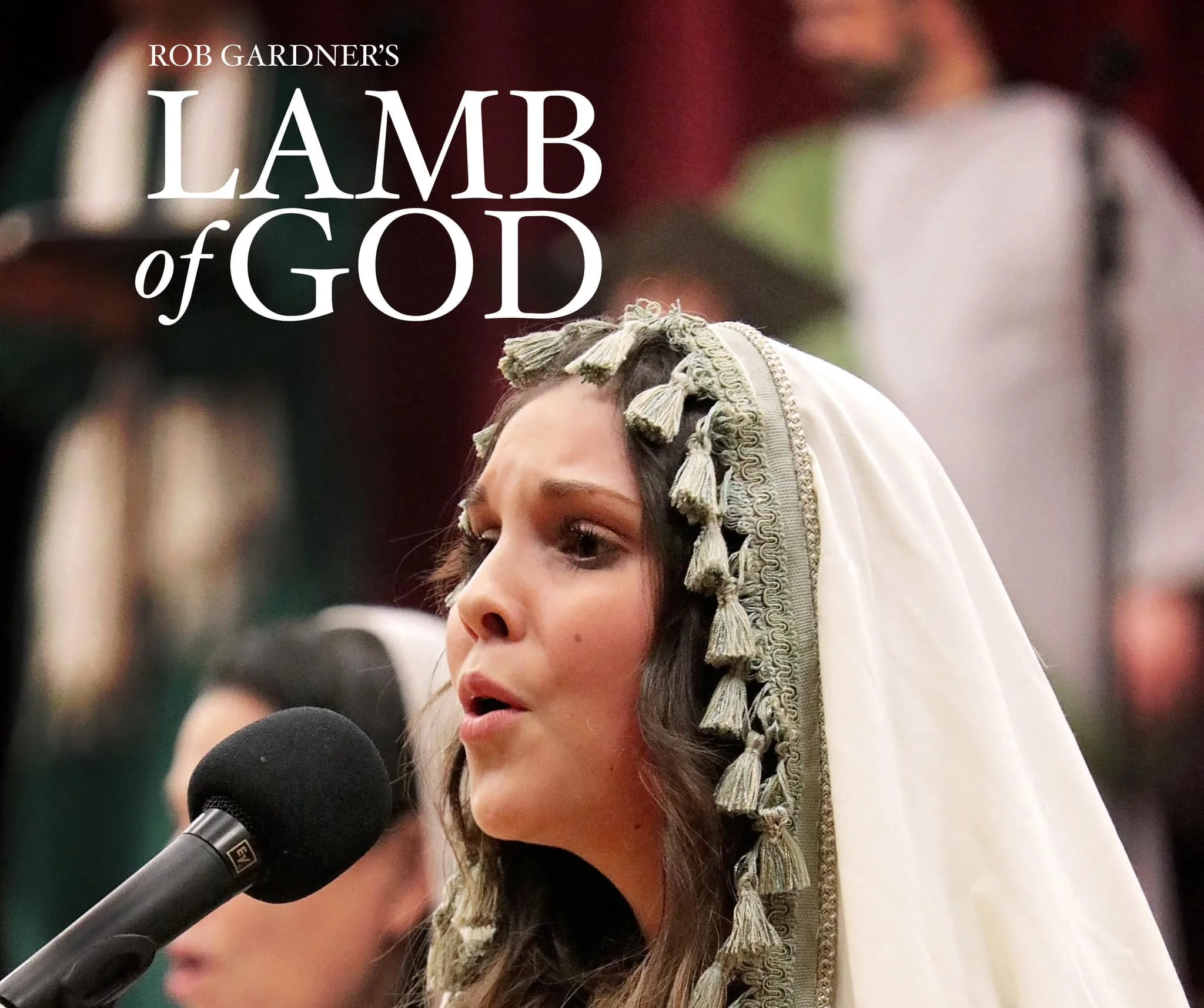 A woman in a traditional dress with a headdress speaking into a microphone during a religious ceremony or event.