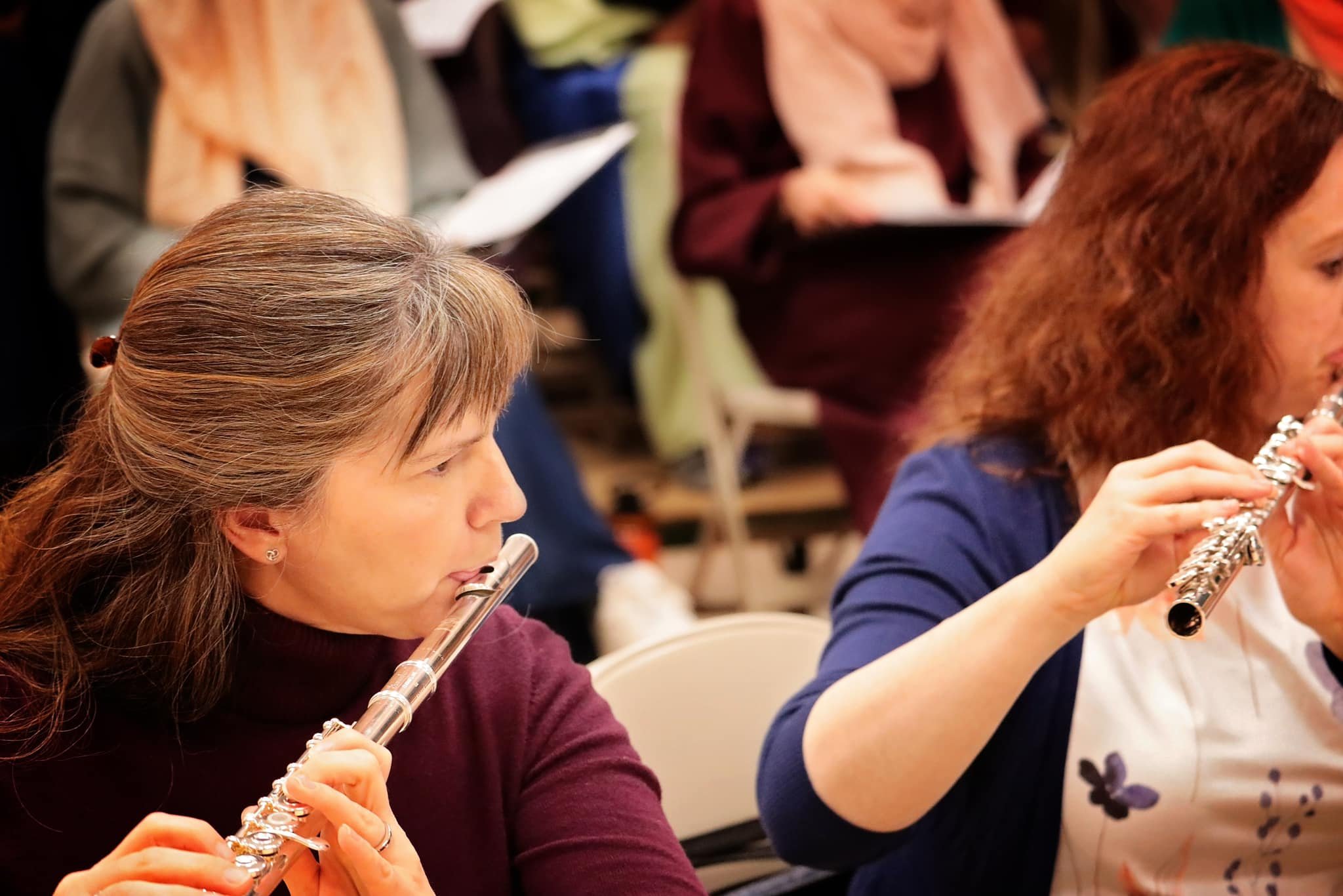 Women playing flutes during a music class or rehearsal.