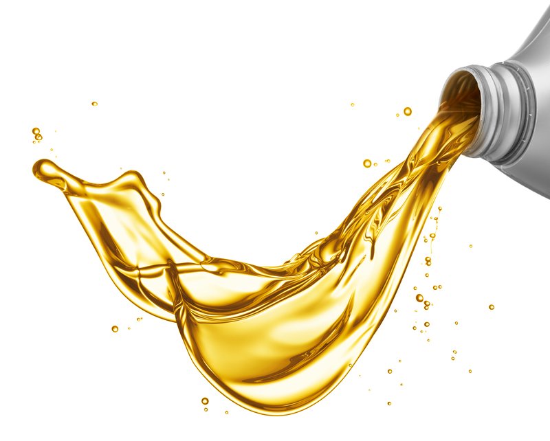 Pouring golden oil from a silver container with a splash effect against a white background.