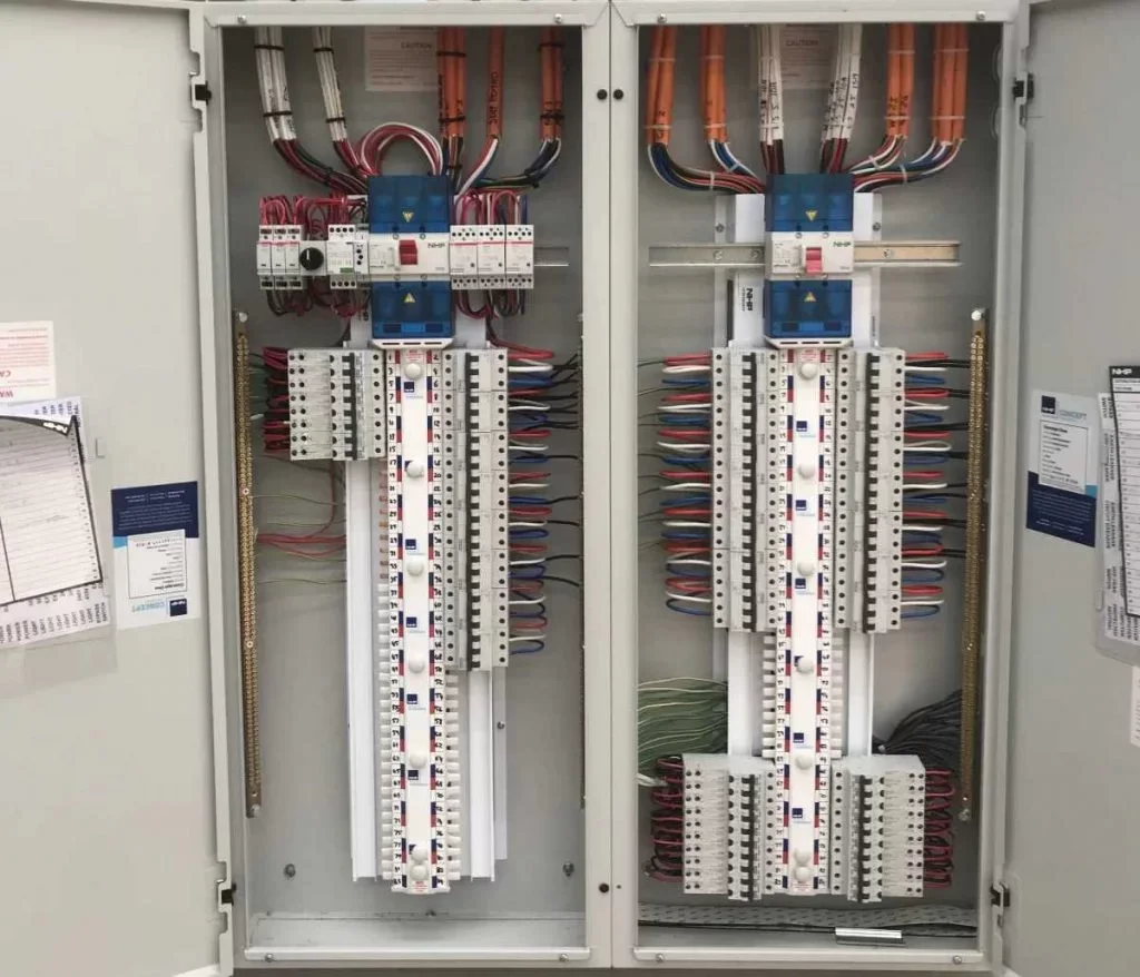 Electrical breaker panel with organized wiring and switches inside a metal cabinet