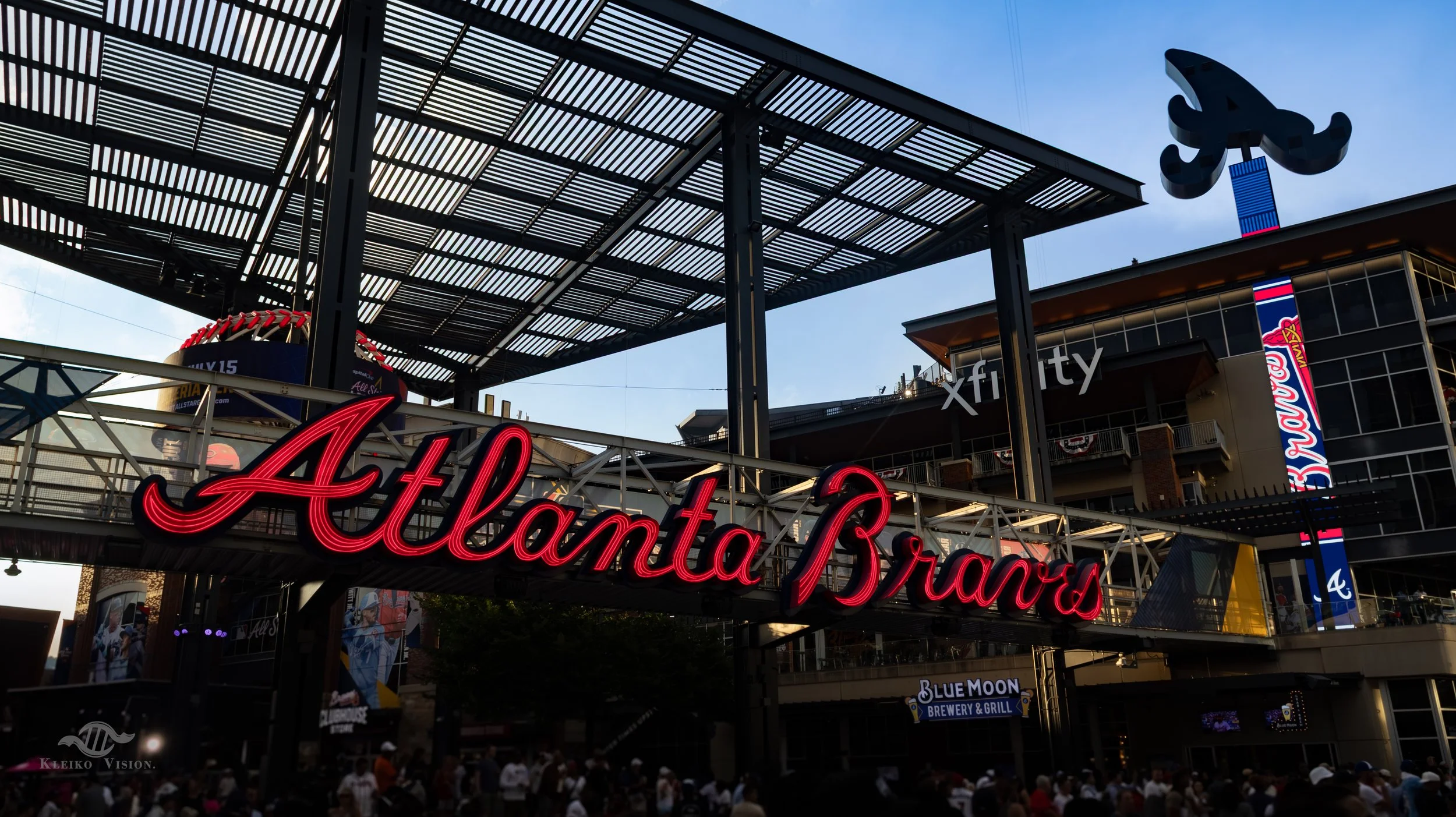 Neon Atlanta Braves sign glowing above the entrance walkway at Truist Park