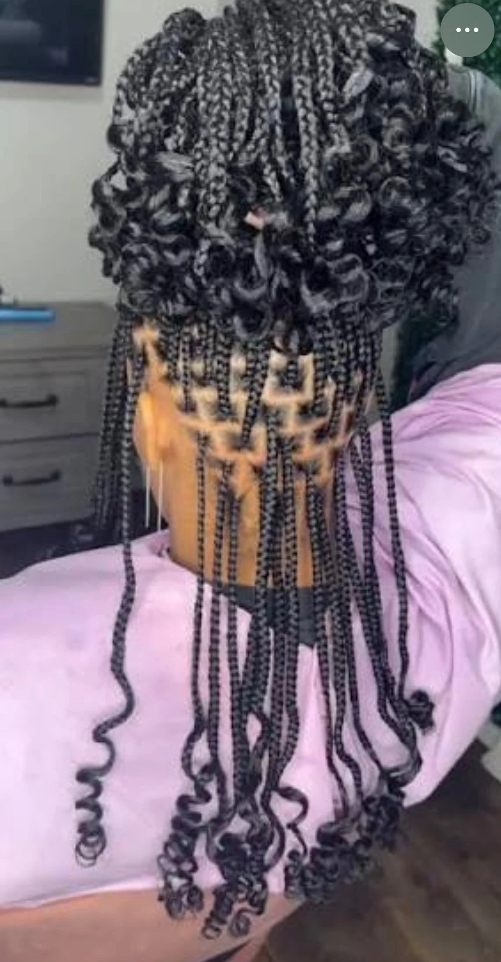 Back view of a person with long, styled box braids.