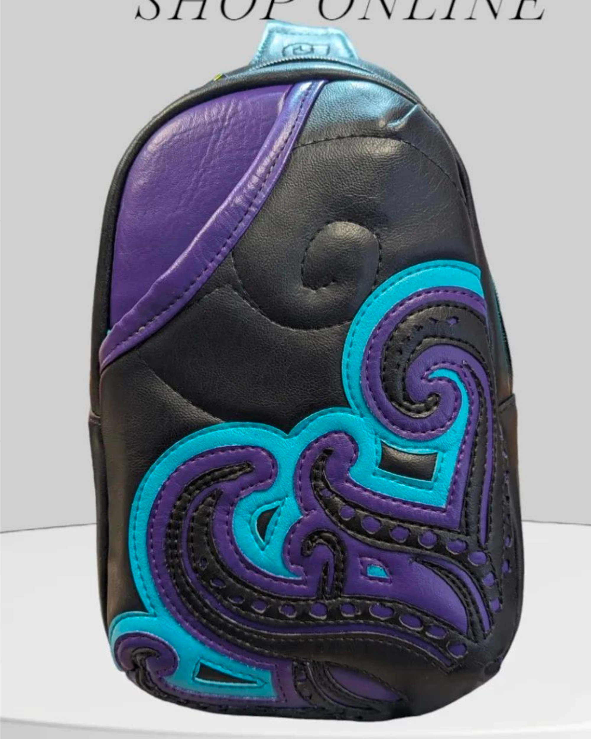 Handmade "Rumor" crossbody bag with purple and black vinyl and a Ursula theme on the front, crafted by Creatively Speaking Designs.