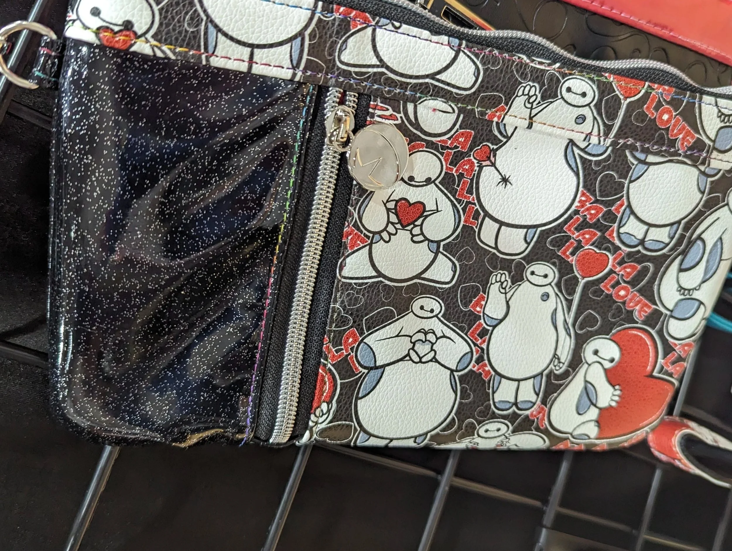A colorful bag with a pattern of Baymax characters from Big Hero 6, some holding hearts, on a black background with the words 'Love' in red and small hearts scattered throughout.