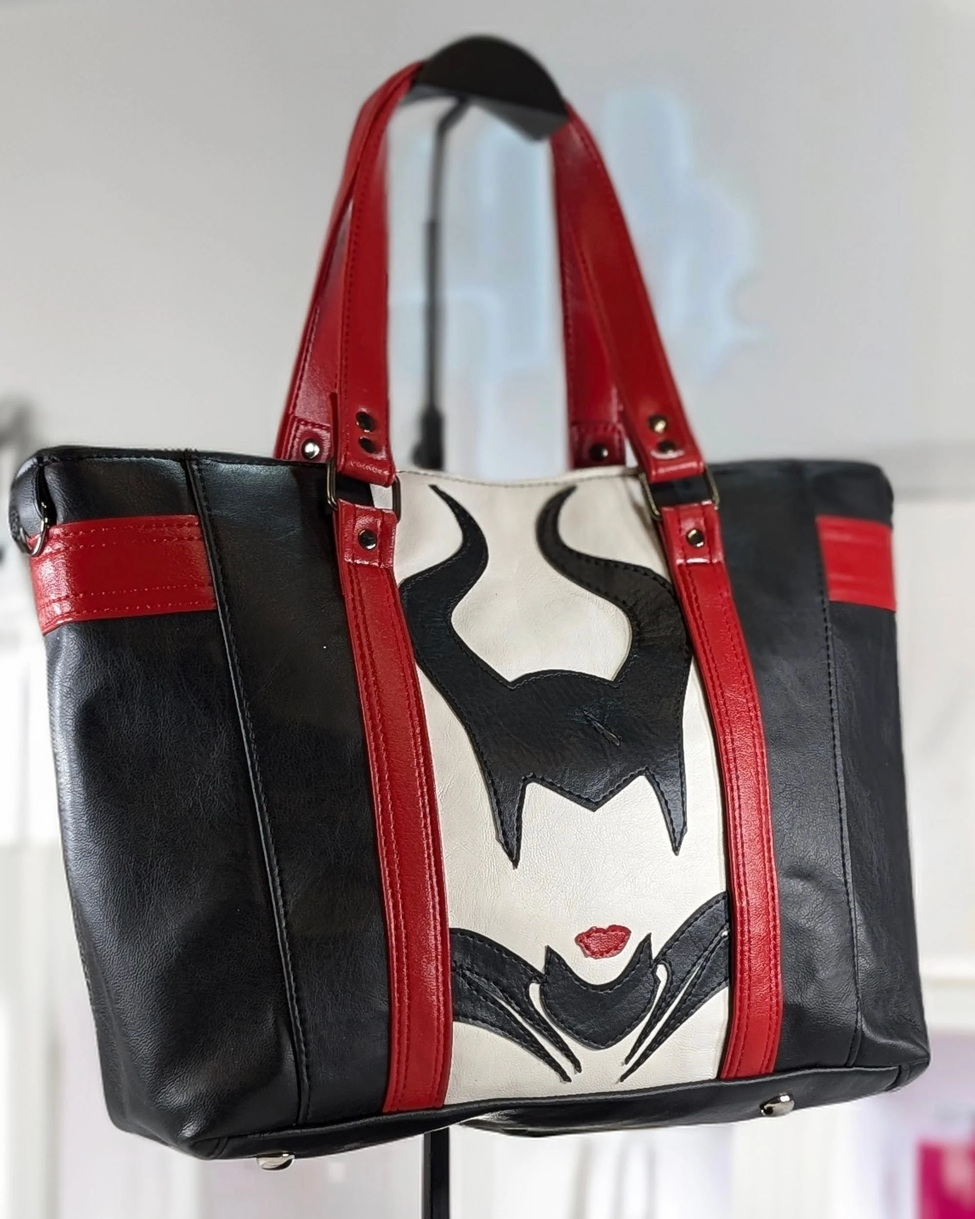 Handmade "Hearsay" tote bag with black and red vinyl and a Maleficent silhouette on the front, crafted by Creatively Speaking Designs.