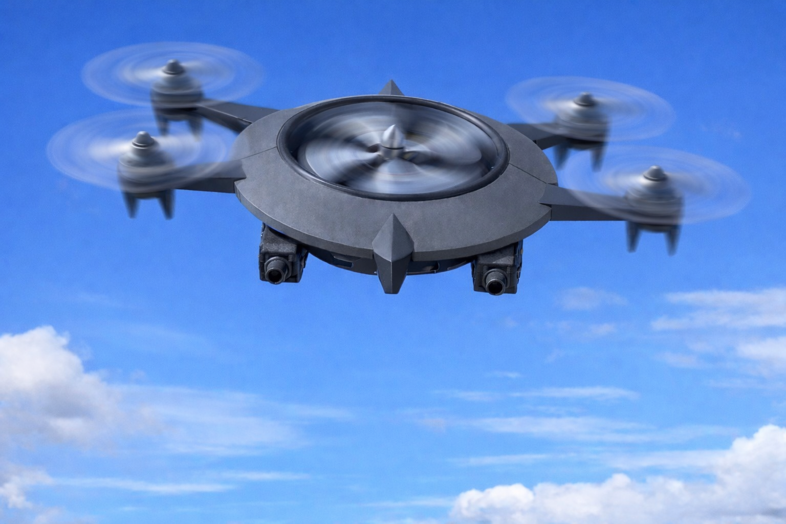 A black flying drone with four propellers against a blue sky with clouds.