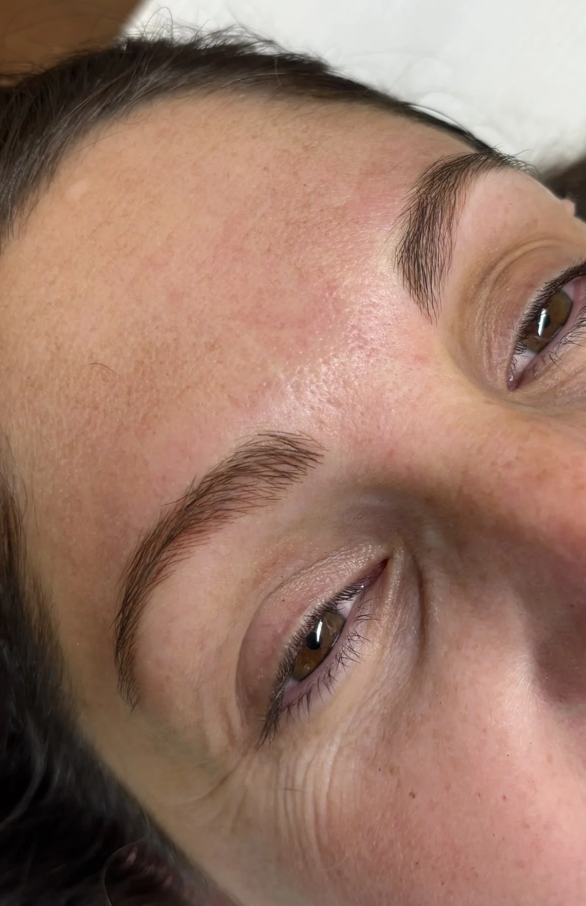Close-up of a woman's face showing her forehead, eyebrows, and part of her eyes with clear skin and natural features.
