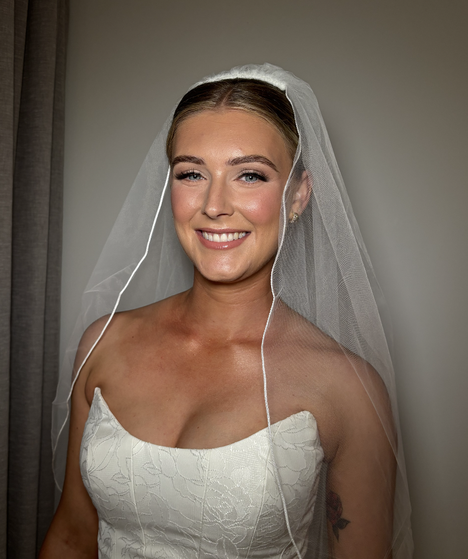 Smiling bride with a veil and strapless wedding dress.