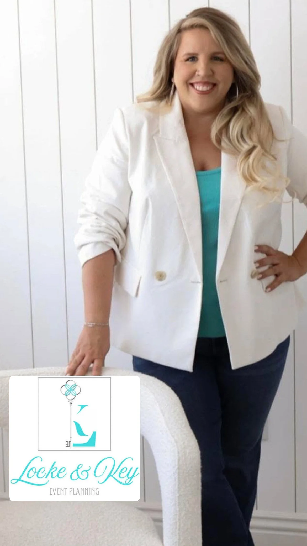A woman with long blonde hair wearing a white blazer and a turquoise top, standing with one hand on her hip and the other resting on a chair, smiling in a bright room with white paneled walls. There is a logo in the bottom left corner for Locke & Key Event Planning.