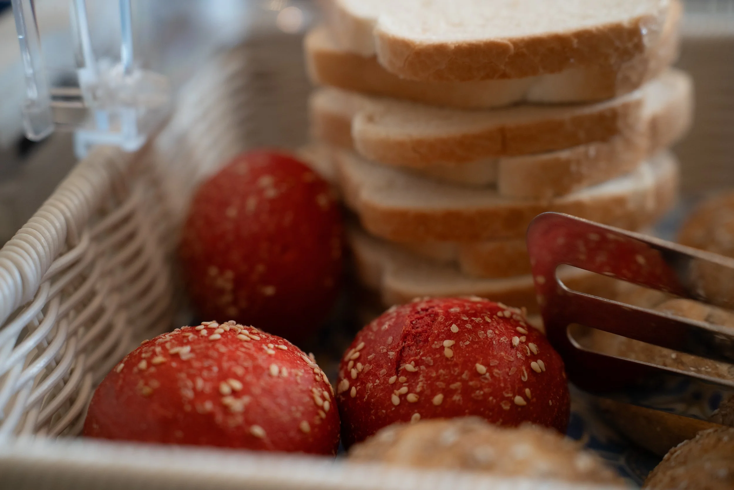 Close-up of a basket with sliced bread and red apples with sprinkles of white.
