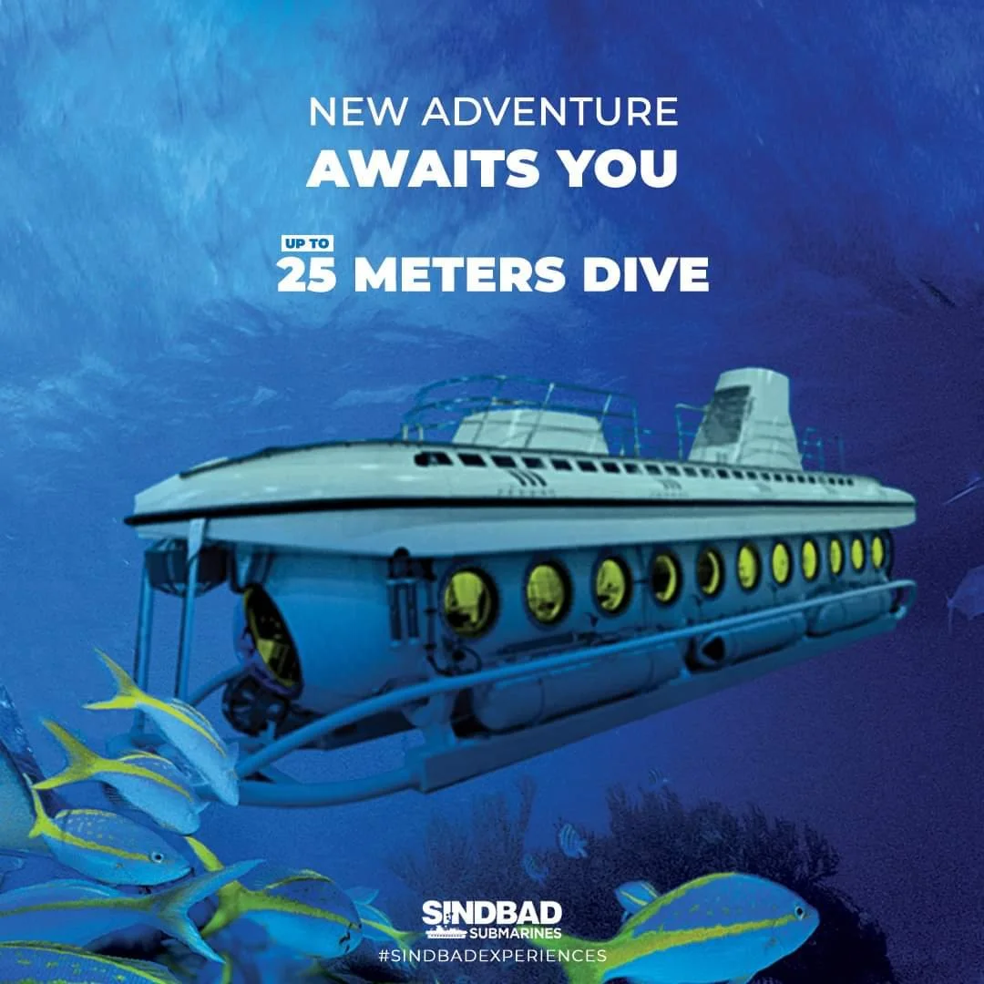 An underwater scene featuring a submarine and yellow fish with blue stripes. The text promotes a diving experience up to 25 meters deep, offered by Sindbad Submarines.
