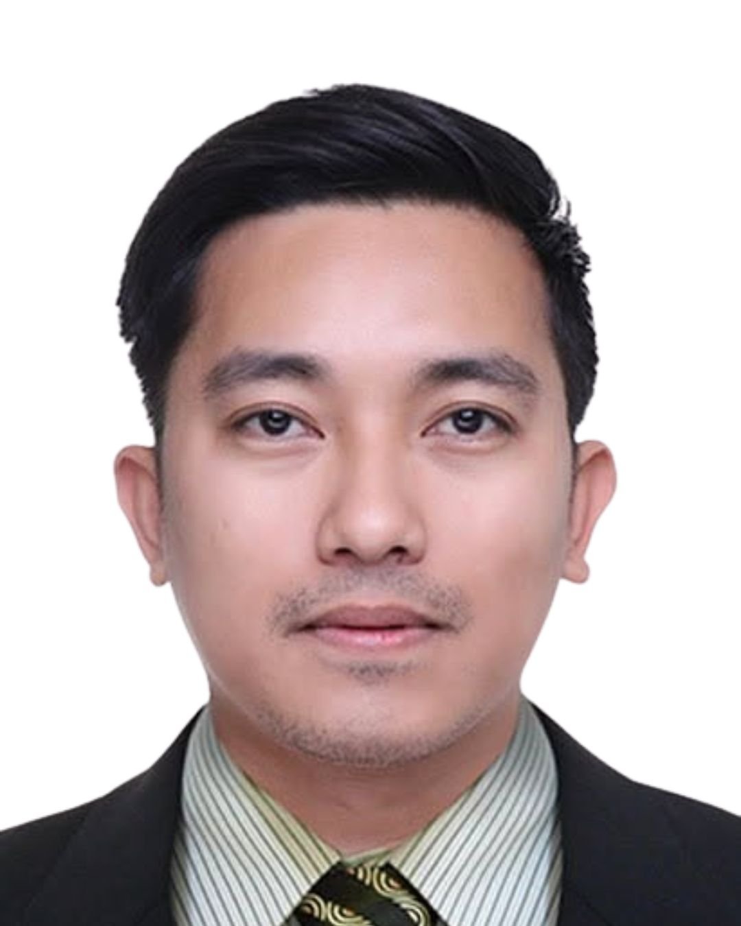A professional headshot of a man with black hair, wearing a dark suit, light-colored shirt, and a patterned tie, against a white background.