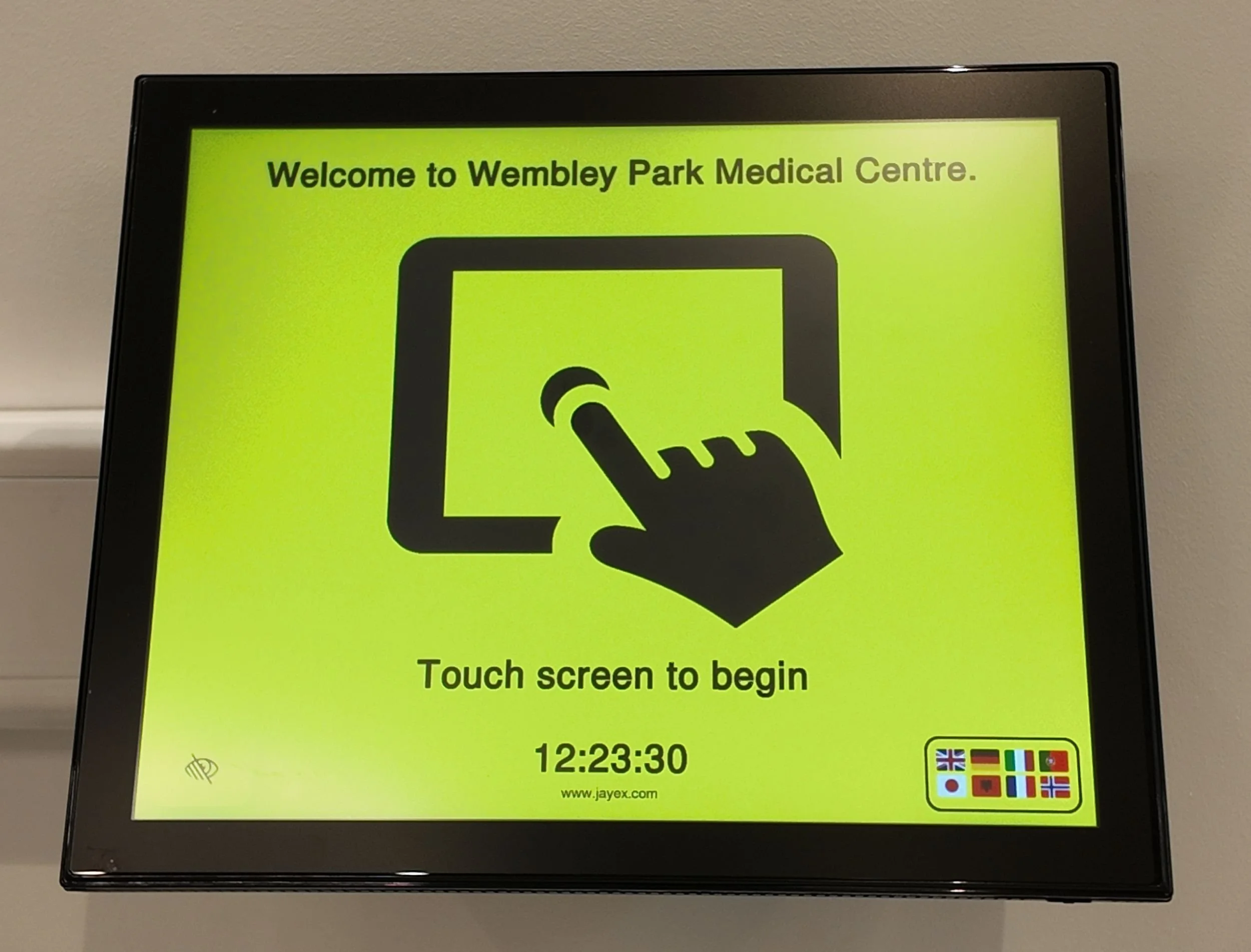a wall mounted patient check in screen in visually impaired mode