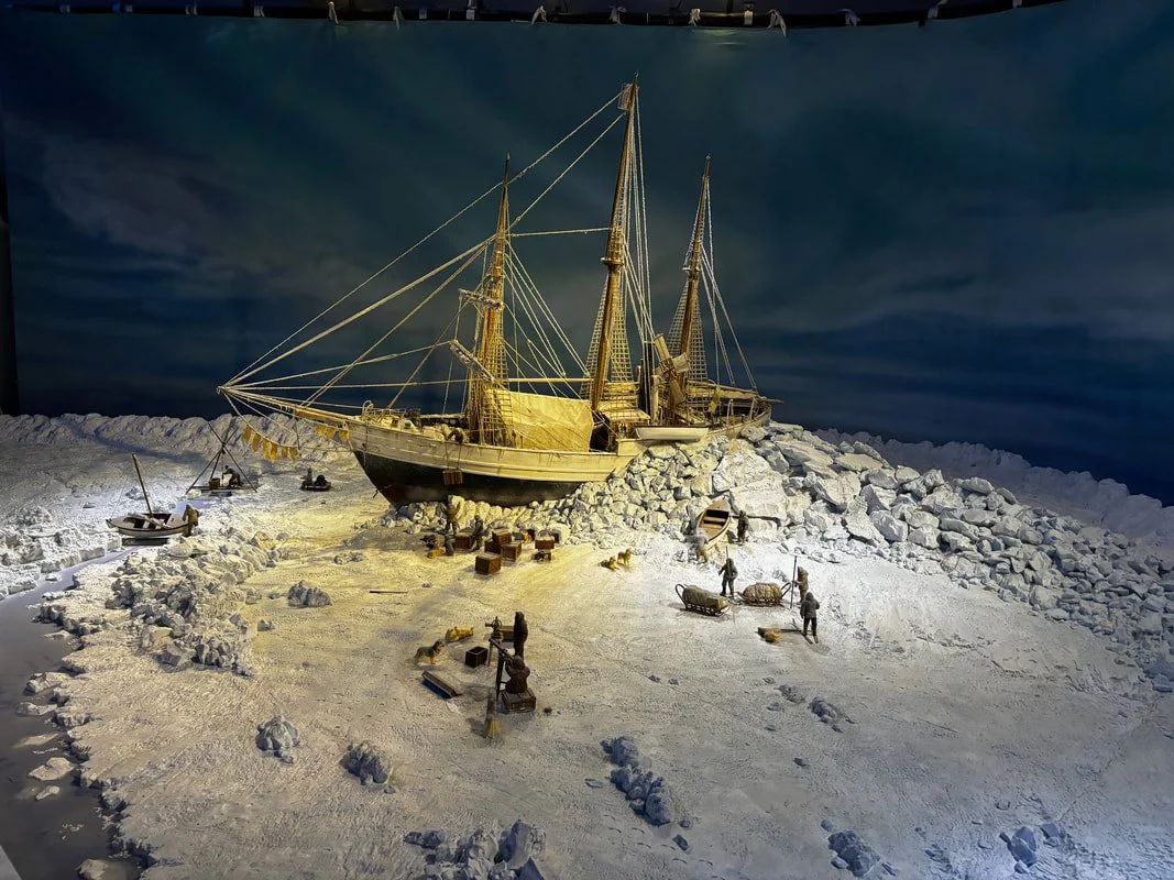 Modello di una nave su un icebreaker, con figure di lavoro e icebergs, in una scena di neve.