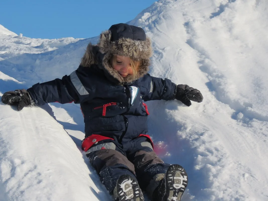 Bambino vestito in abbigliamento invernale in piedi sulla neve.